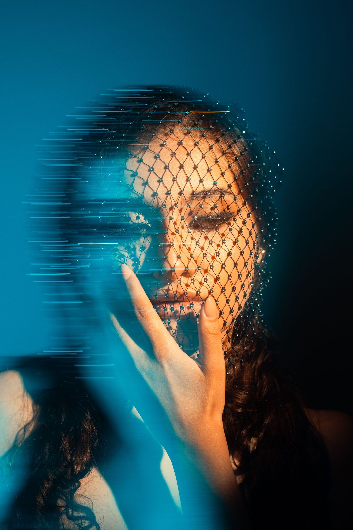 Artistic portrait with fishnet pattern and motion blur effect in blue and orange tones.