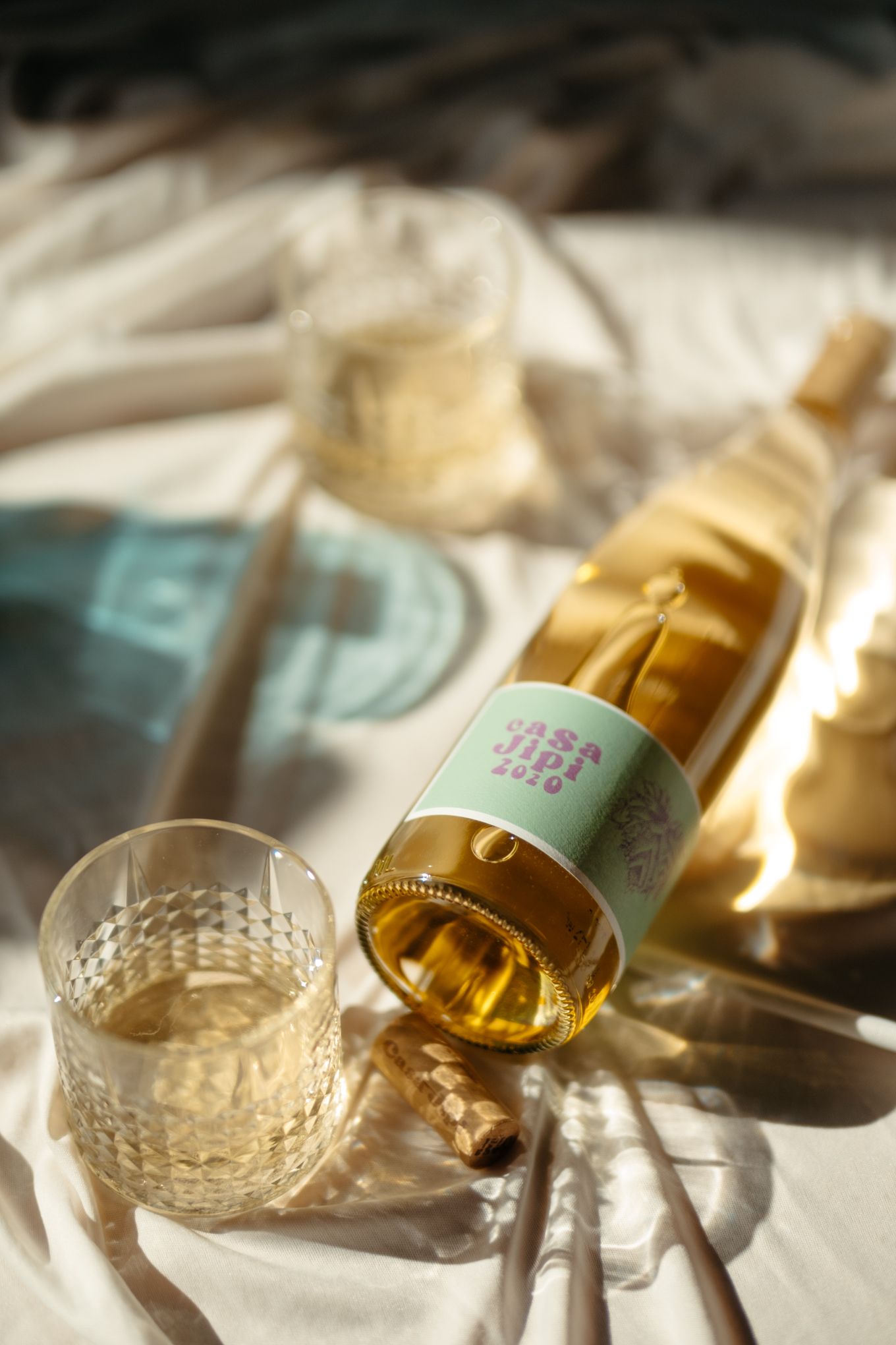 Light streams through a crystal wine glass as golden white wine is being poured in a elegant sequence of shots.