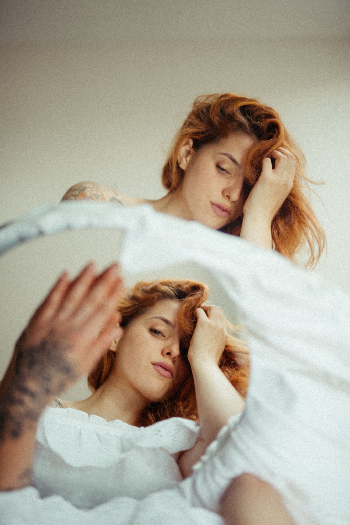 Artistic double exposure portrait in white reflected in mirror.