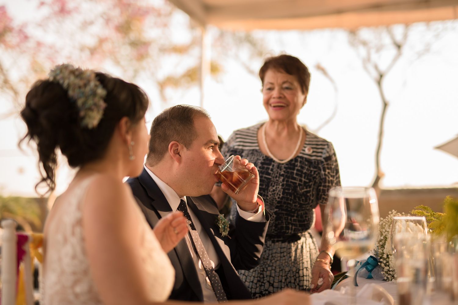 Wedding reception moment with guests enjoying drinks and conversation outdoors.