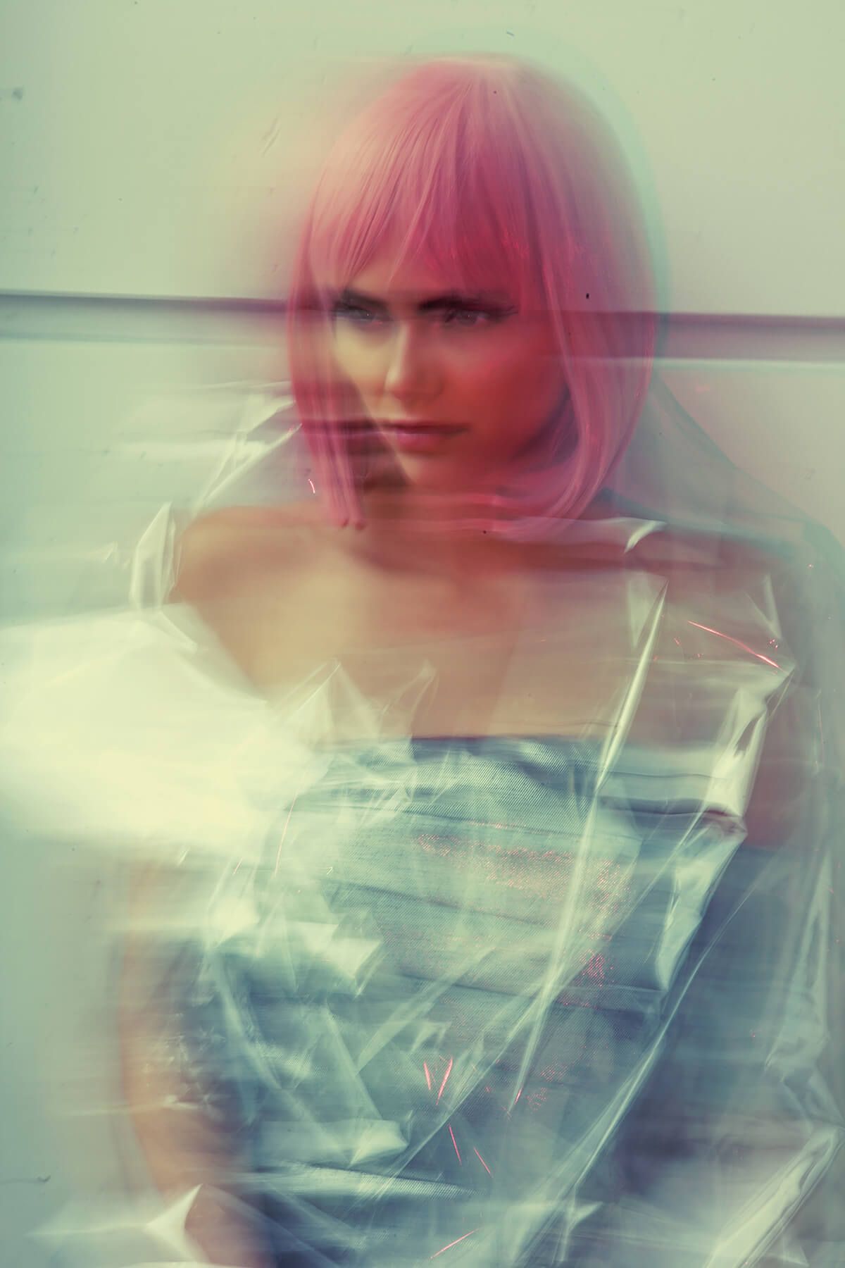 Dreamy double exposure portrait with soft pink tones and ethereal motion blur.