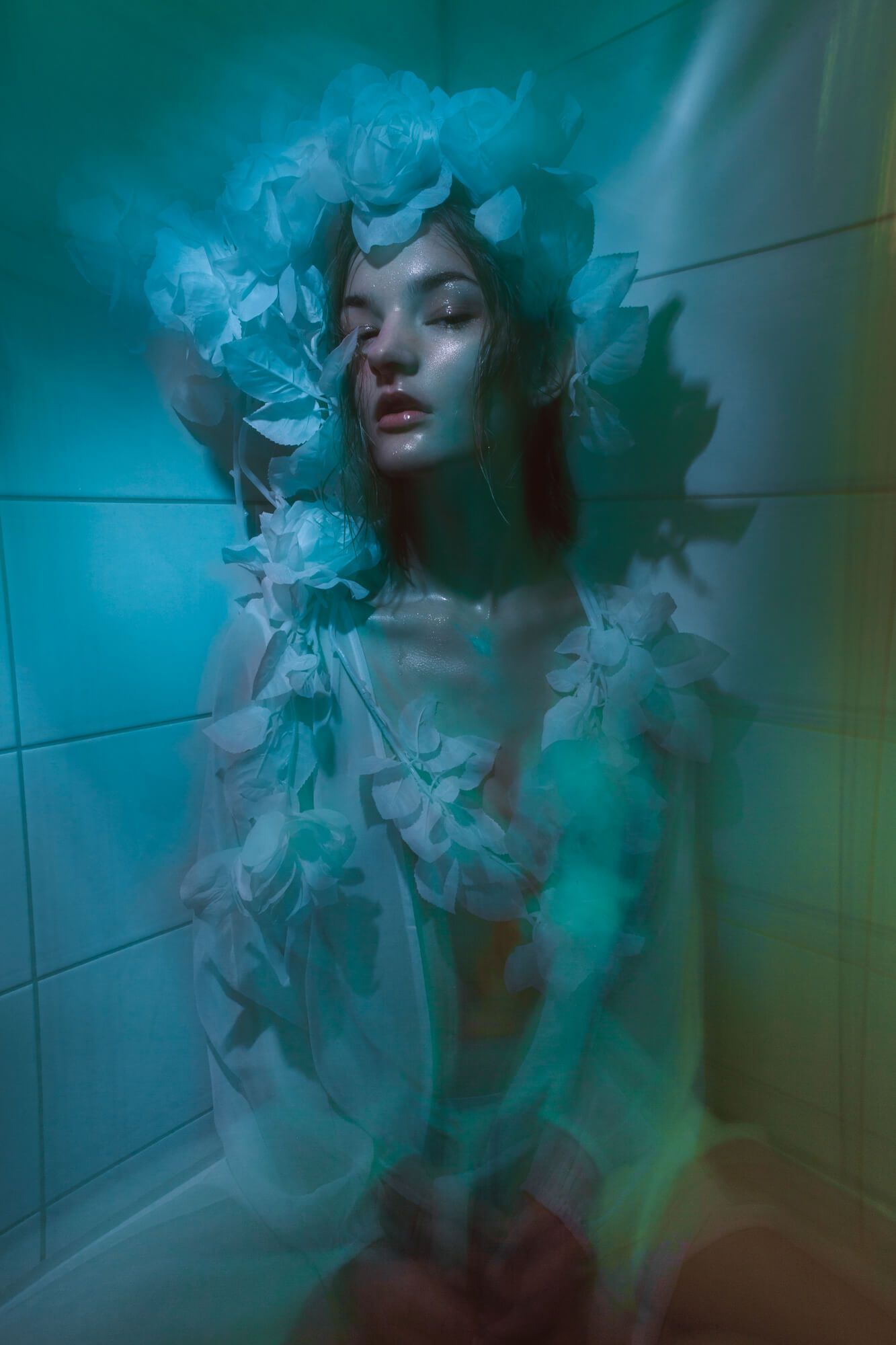 Ethereal bathroom portrait with blue lighting and floral decorative elements.