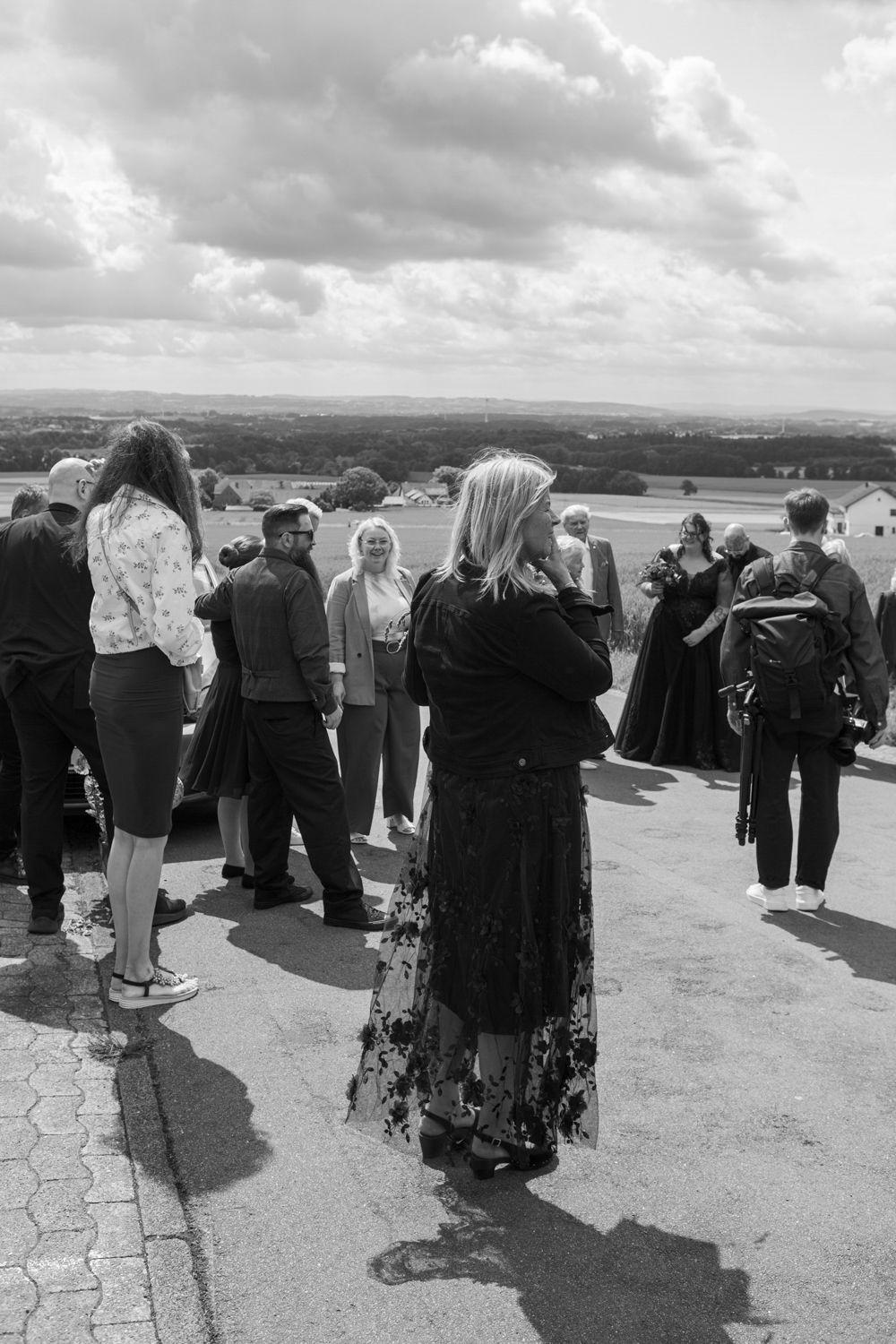 A group of Muslim women in traditional dress gathered on a hillside overlooking a scenic landscape.
