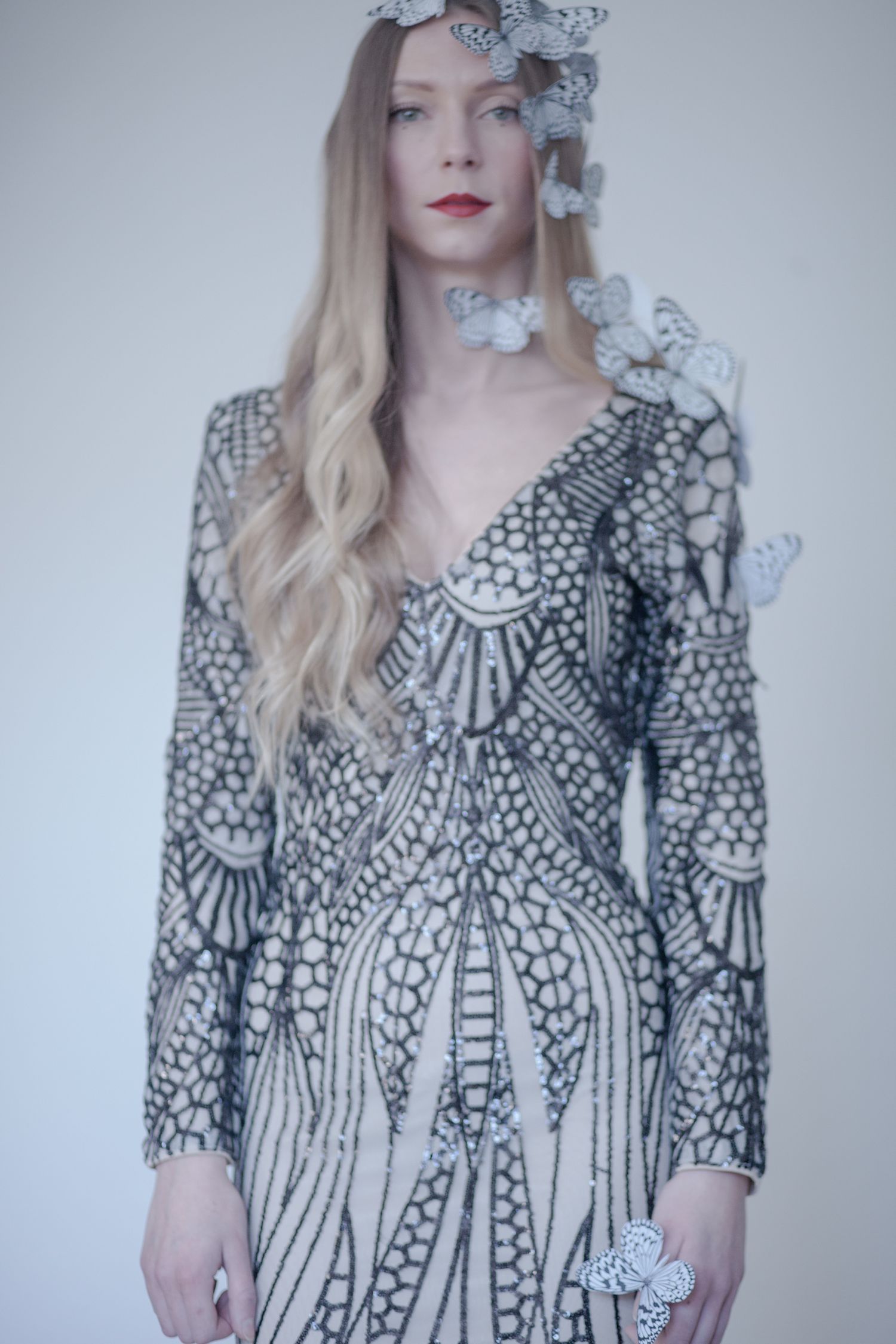 Elegant long dress with intricate black and white geometric patterns adorned with butterfly accents.