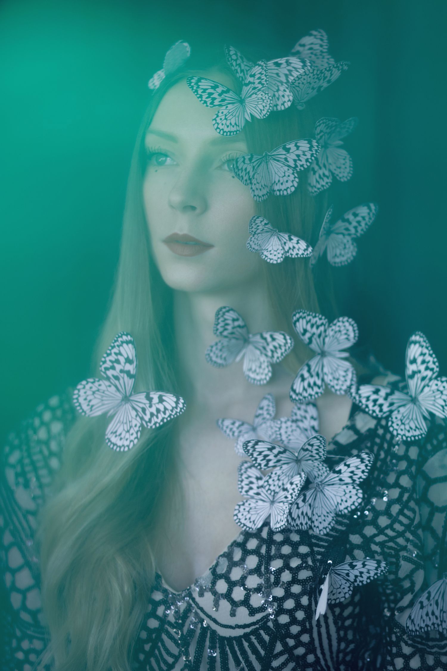 Dreamy portrait with delicate white butterflies on turquoise background.