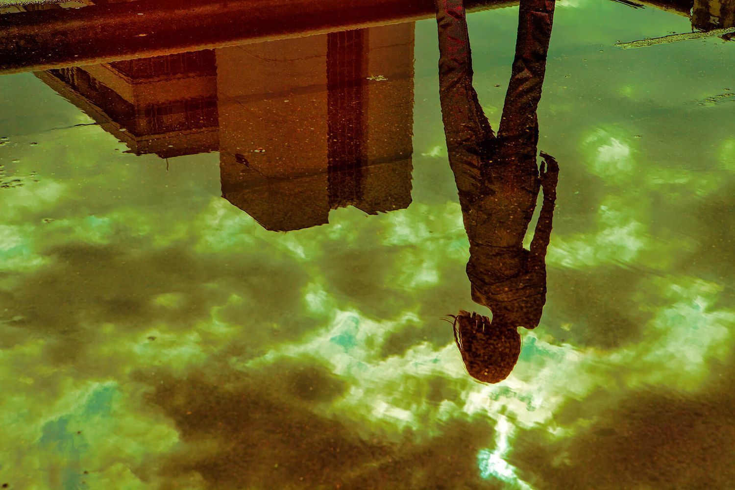 Atmospheric urban scene with stormy green sky and upside-down perspective.