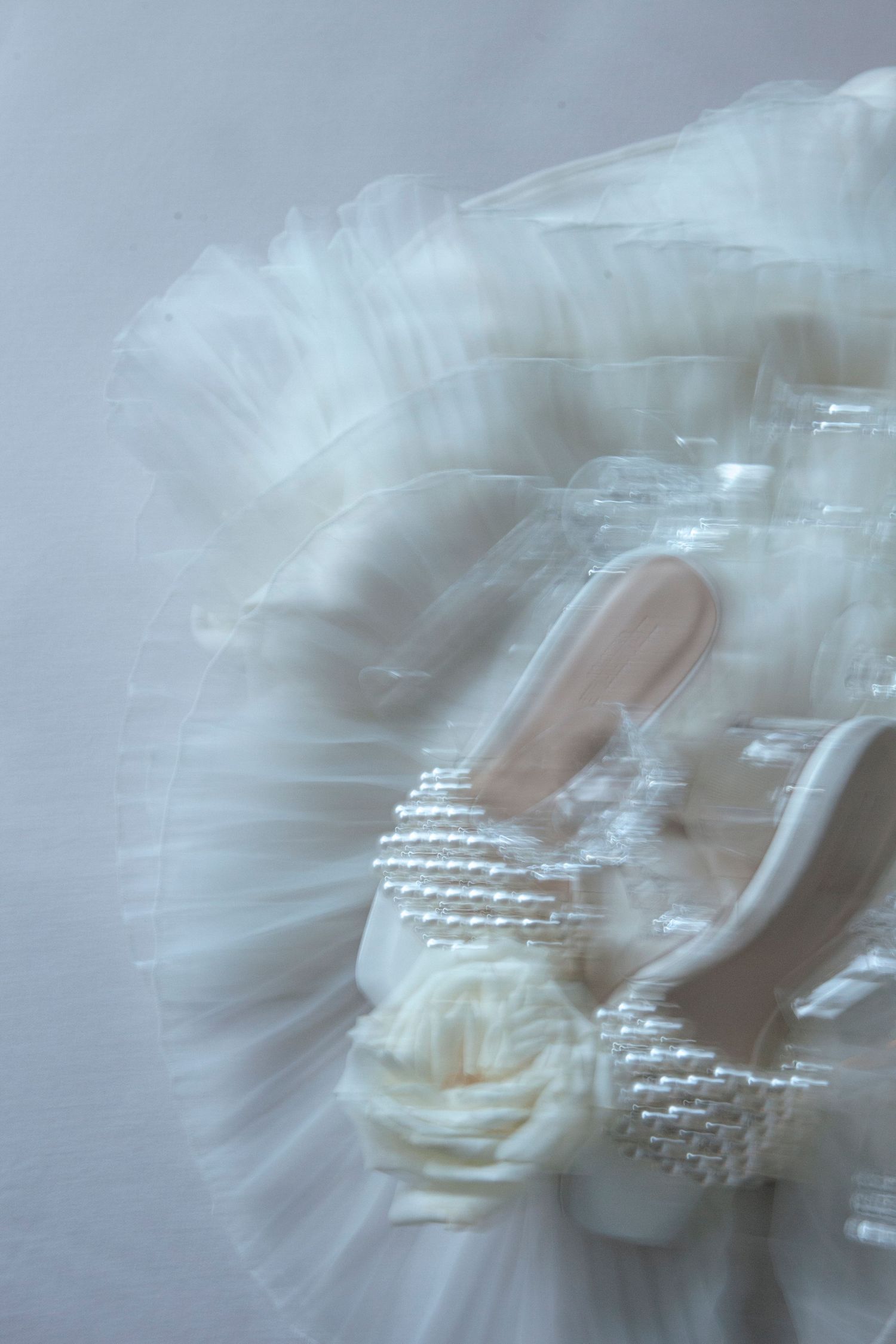 Ethereal close-up of wedding dress details with delicate beading and fabric layers.