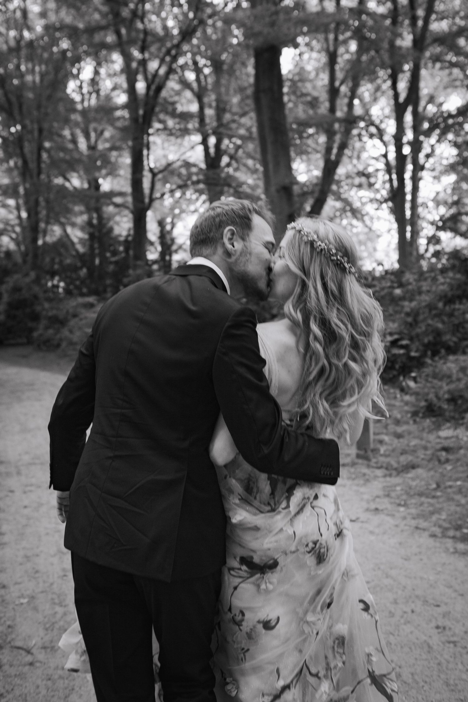 A series of romantic black and white wedding photos showing intimate moments between a couple in a garden setting.
