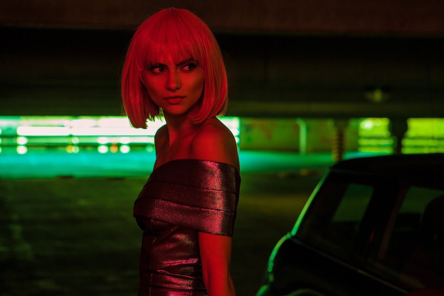 Dramatic nightclub scene bathed in red and green neon lighting.