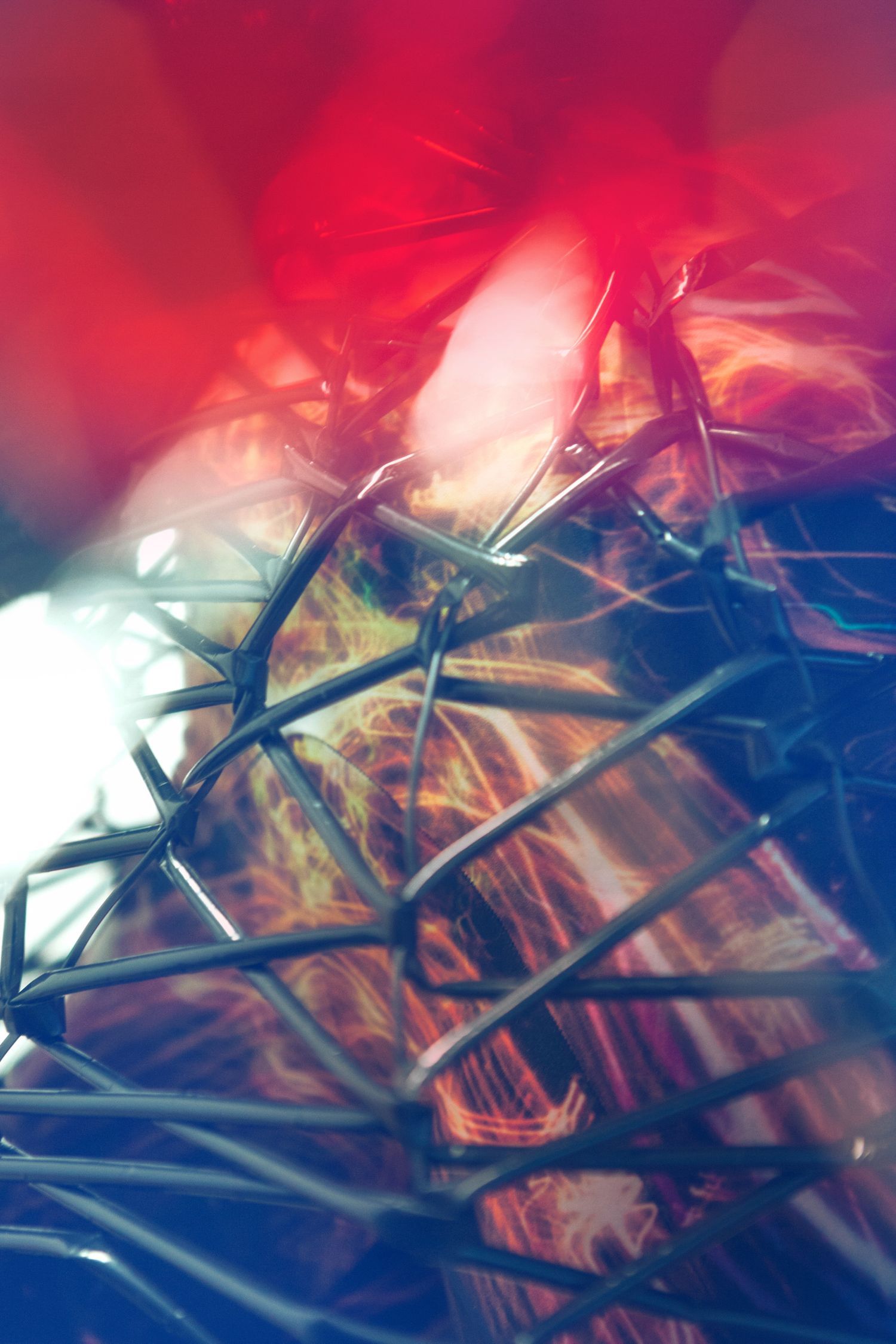 Abstract red and blue photograph with metallic geometric patterns.