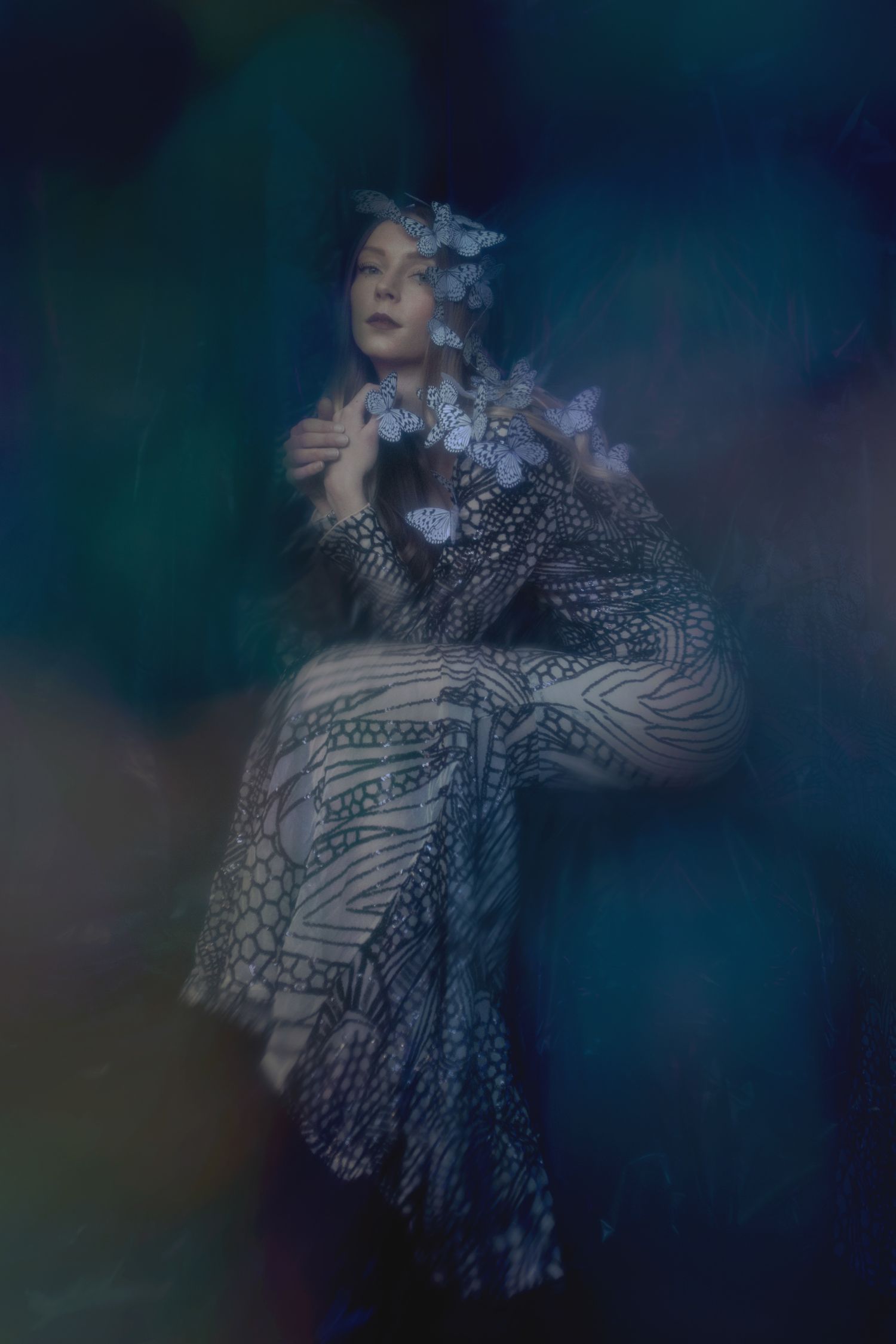 Artistic portrait with geometric patterned dress in moody dark tones.