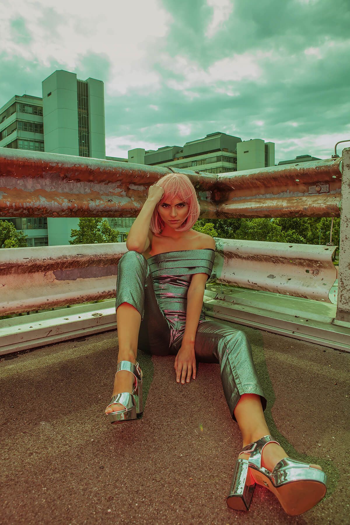 Retro-styled fashion photo showing someone in metallic platform shoes and mint green outfit sitting on concrete steps.