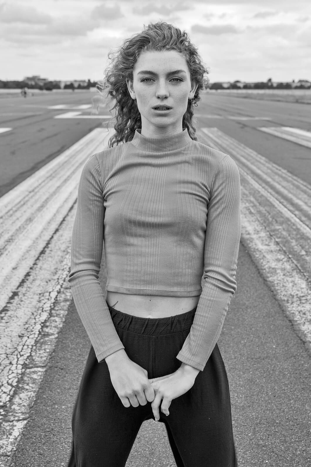 Black and white portrait series on an empty runway with minimalist composition.