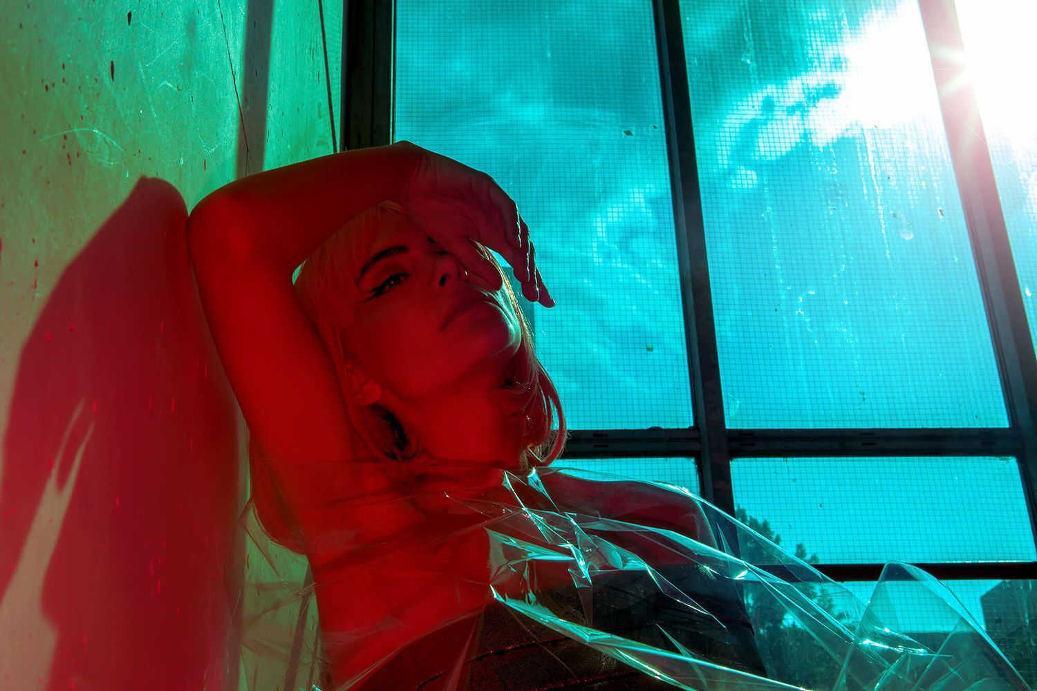 Underwater-style photography with turquoise lighting and deep red floral elements.