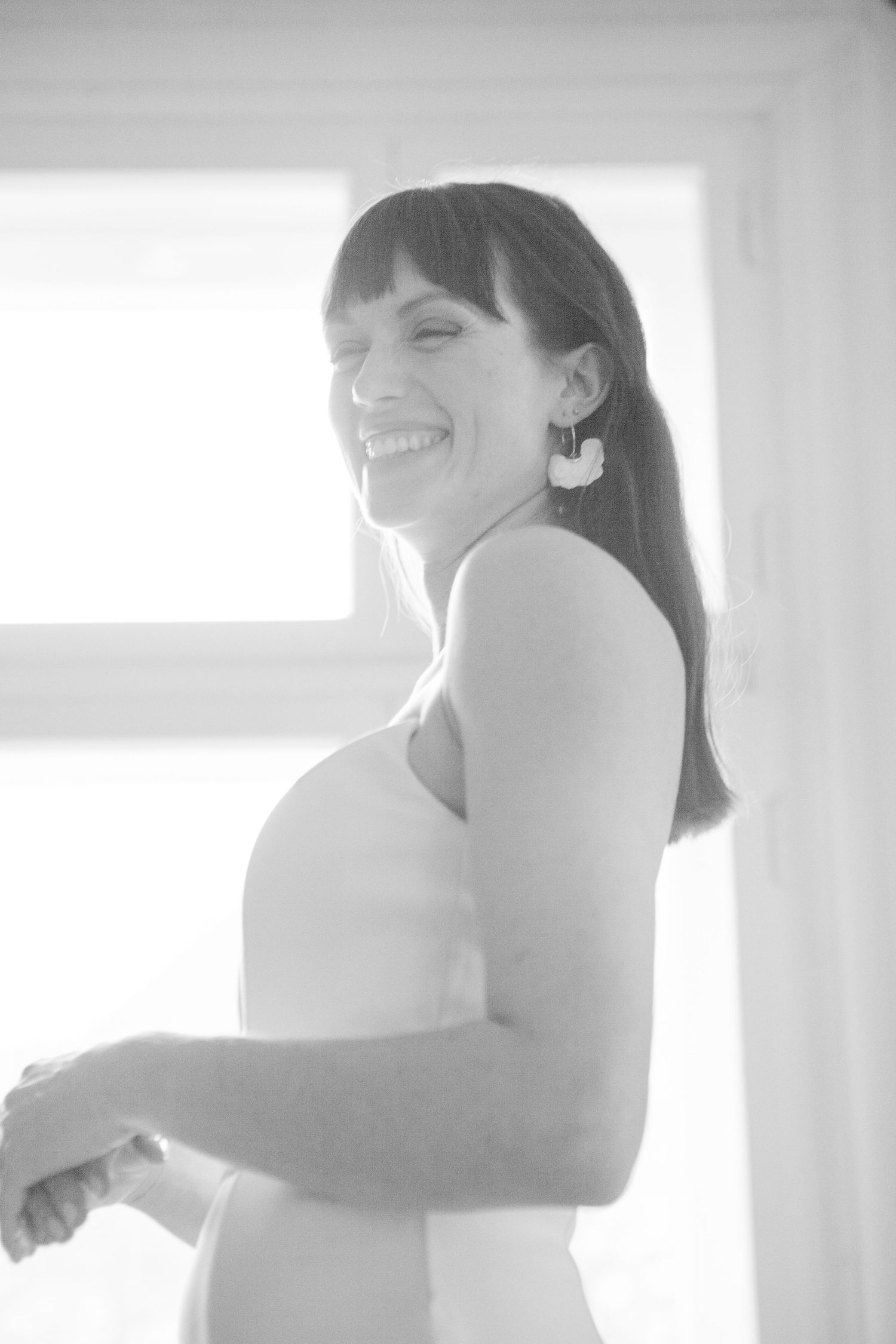 Black and white portrait of a radiant bride with long hair smiling brightly.