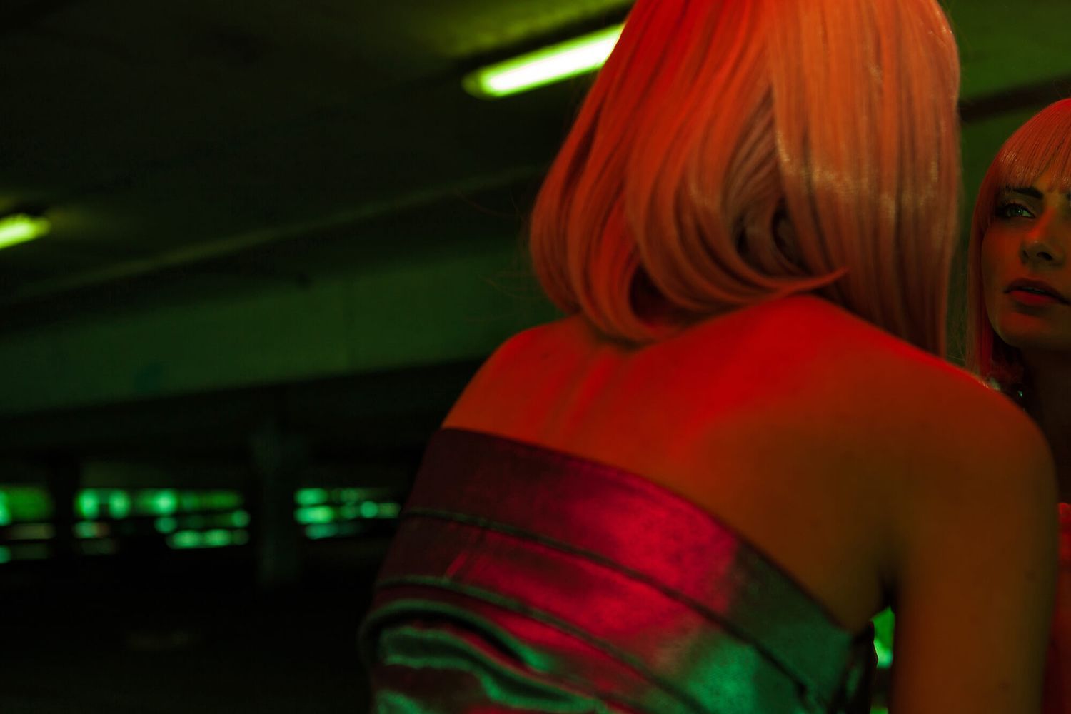 Moody nightclub scene illuminated with green and red lighting effects.