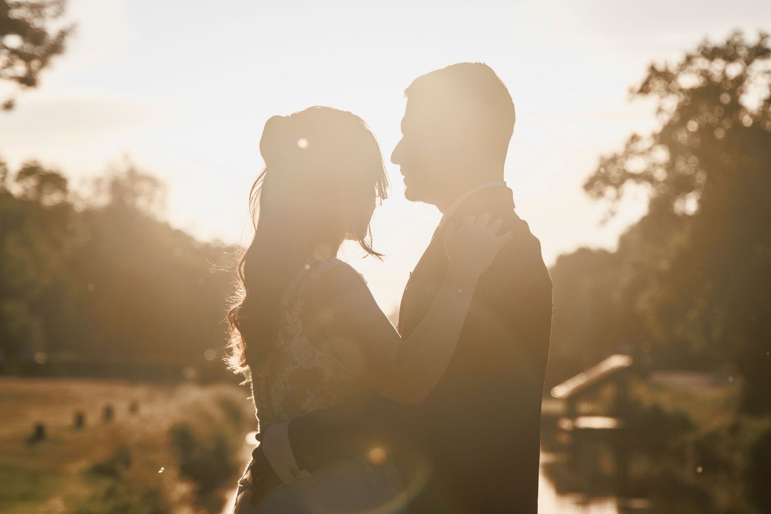 Couple de mariés s’embrassant au coucher du soleil en Bretagne