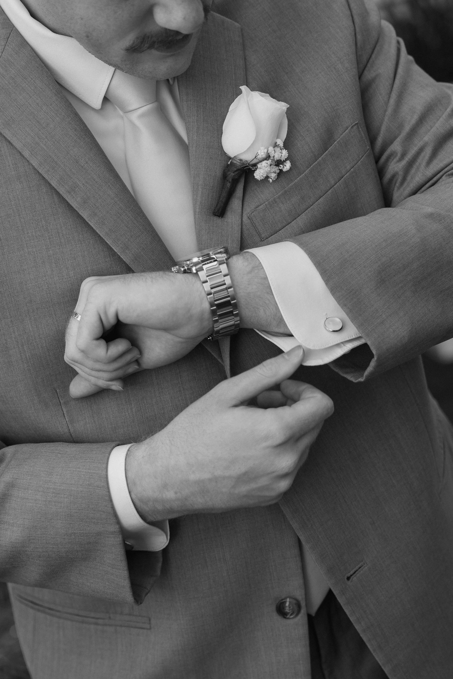 A series of black and white photos showing hands adjusting suit jacket sleeves and cuffs.