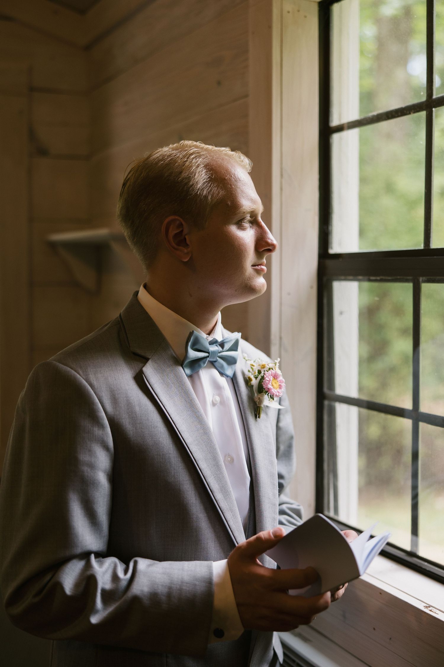 Five-panel panoramic sequence showing a person in a dark suit looking pensively out a sunlit window.