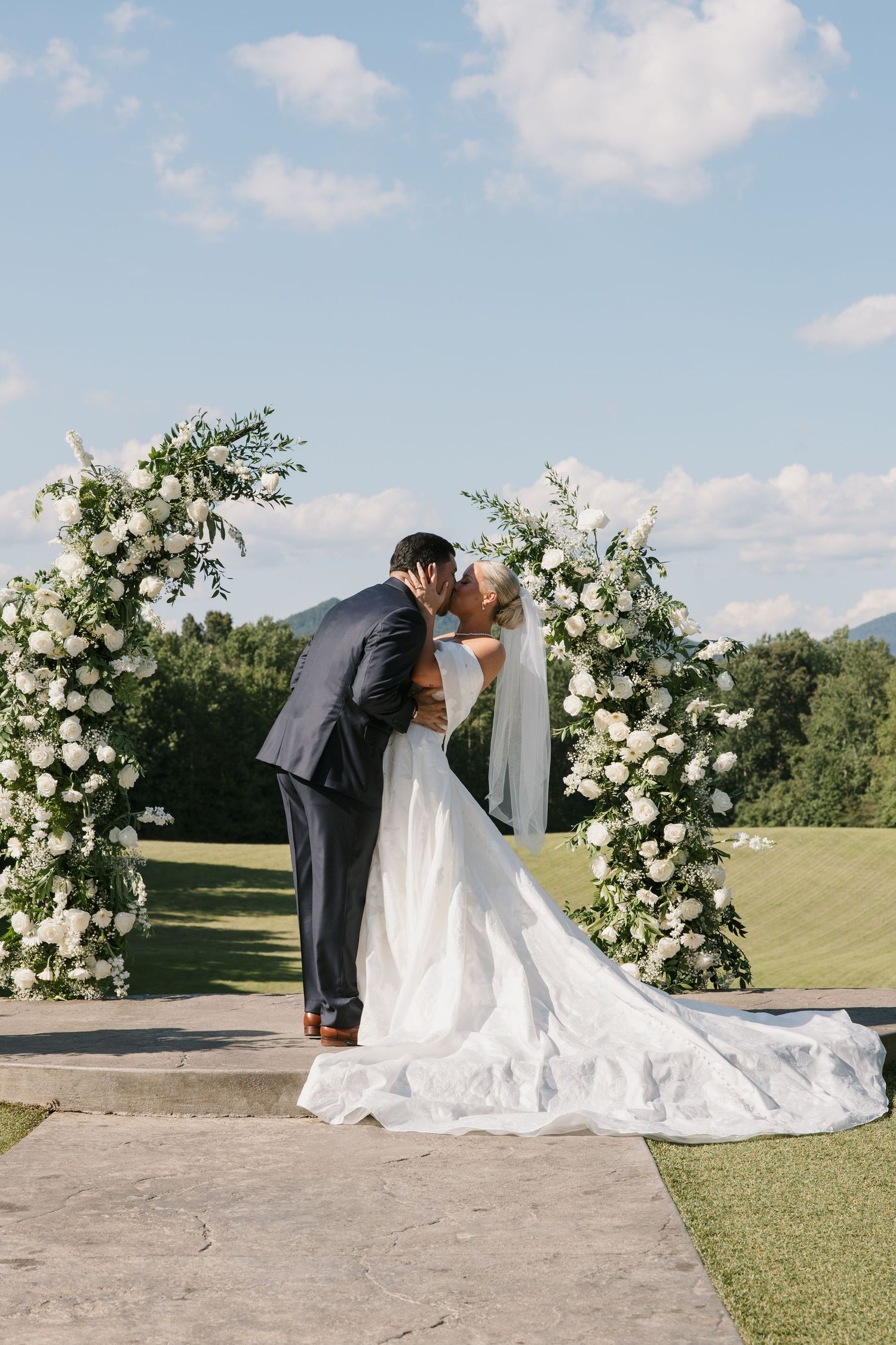 Romantic wedding photography montage showing couple embracing under white floral arch in an outdoor garden setting.