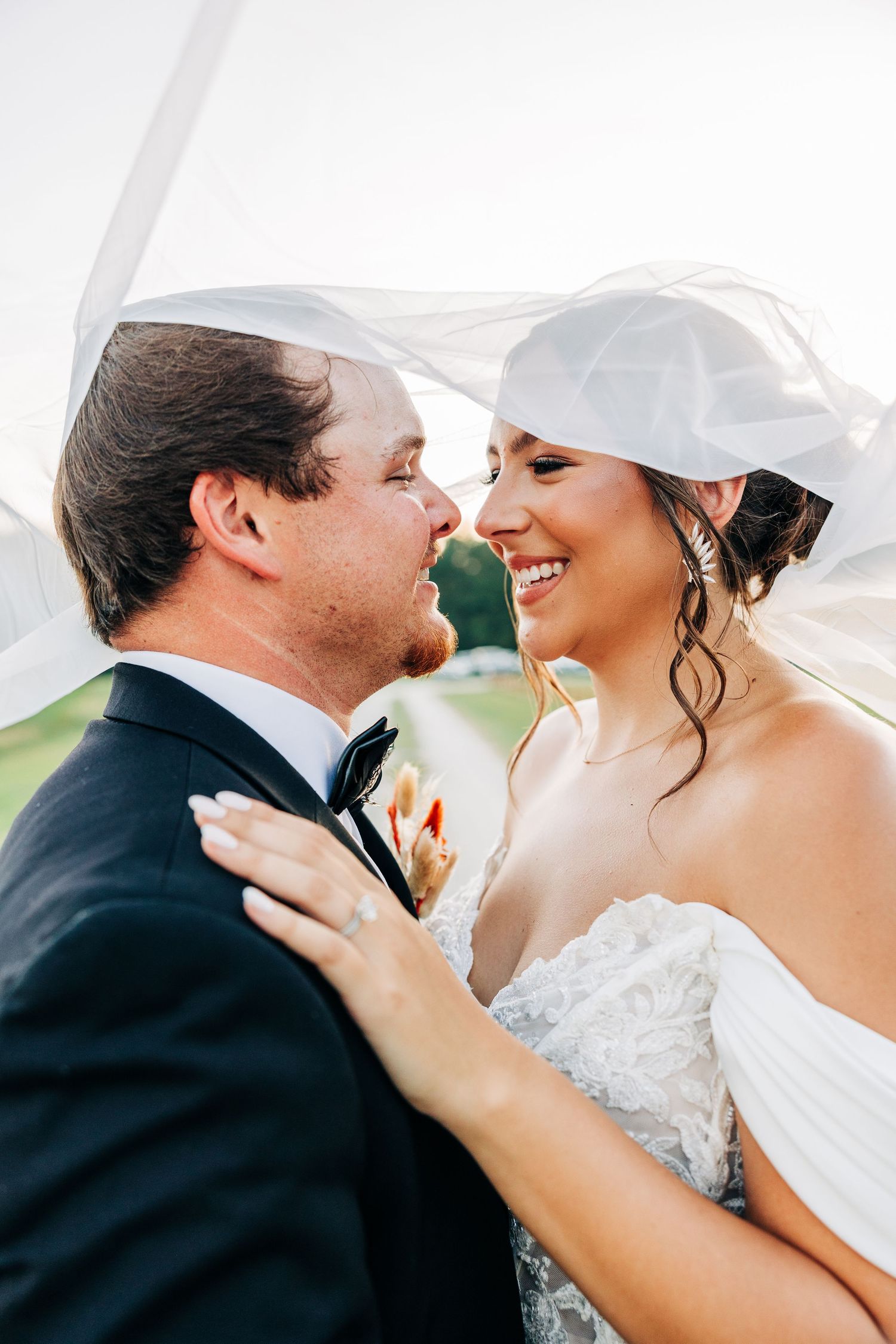 A tender moment captured between a couple in wedding attire sharing intimate glances and embraces.