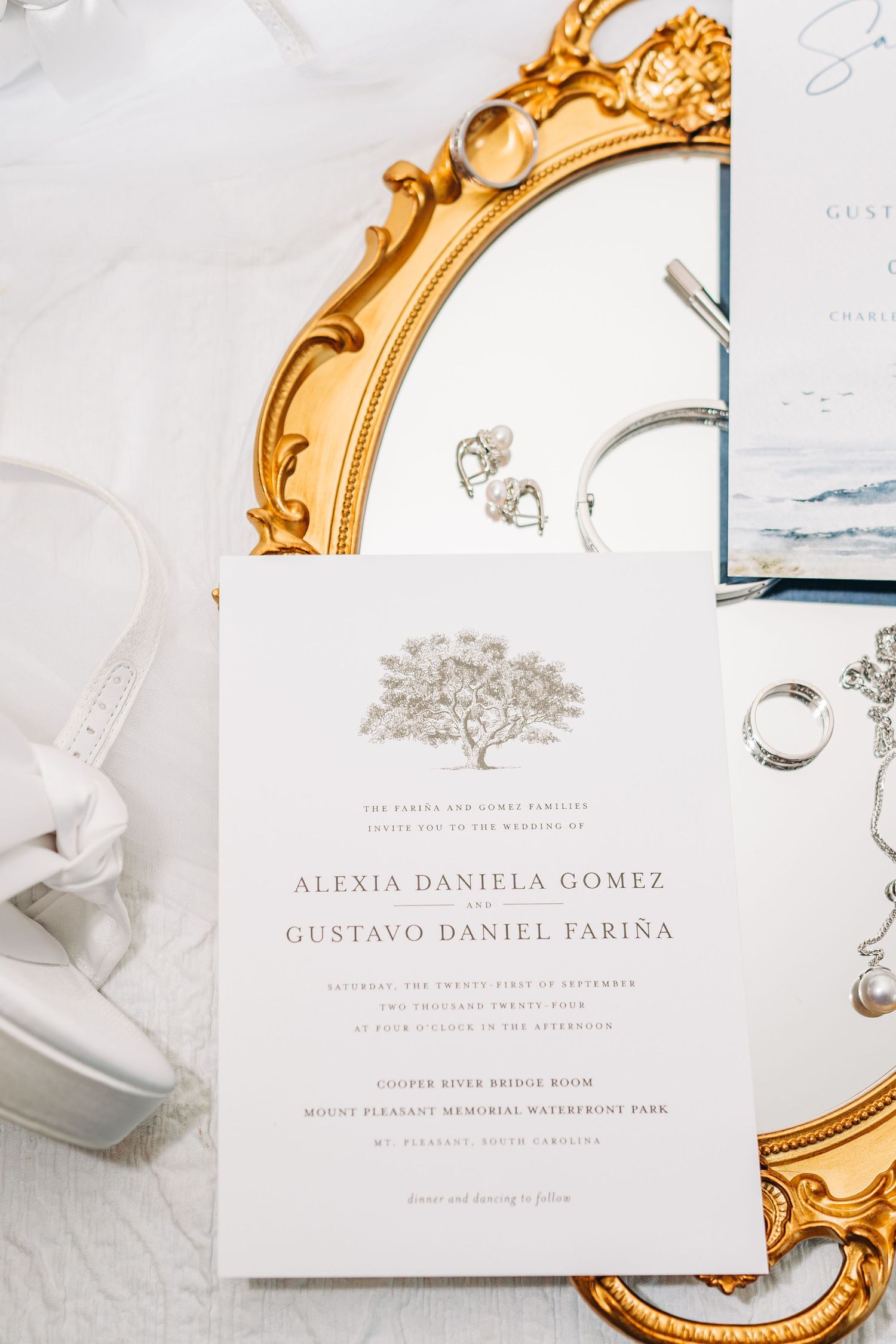 Elegant wedding invitations with gold ornate frames and delicate calligraphy on white paper.