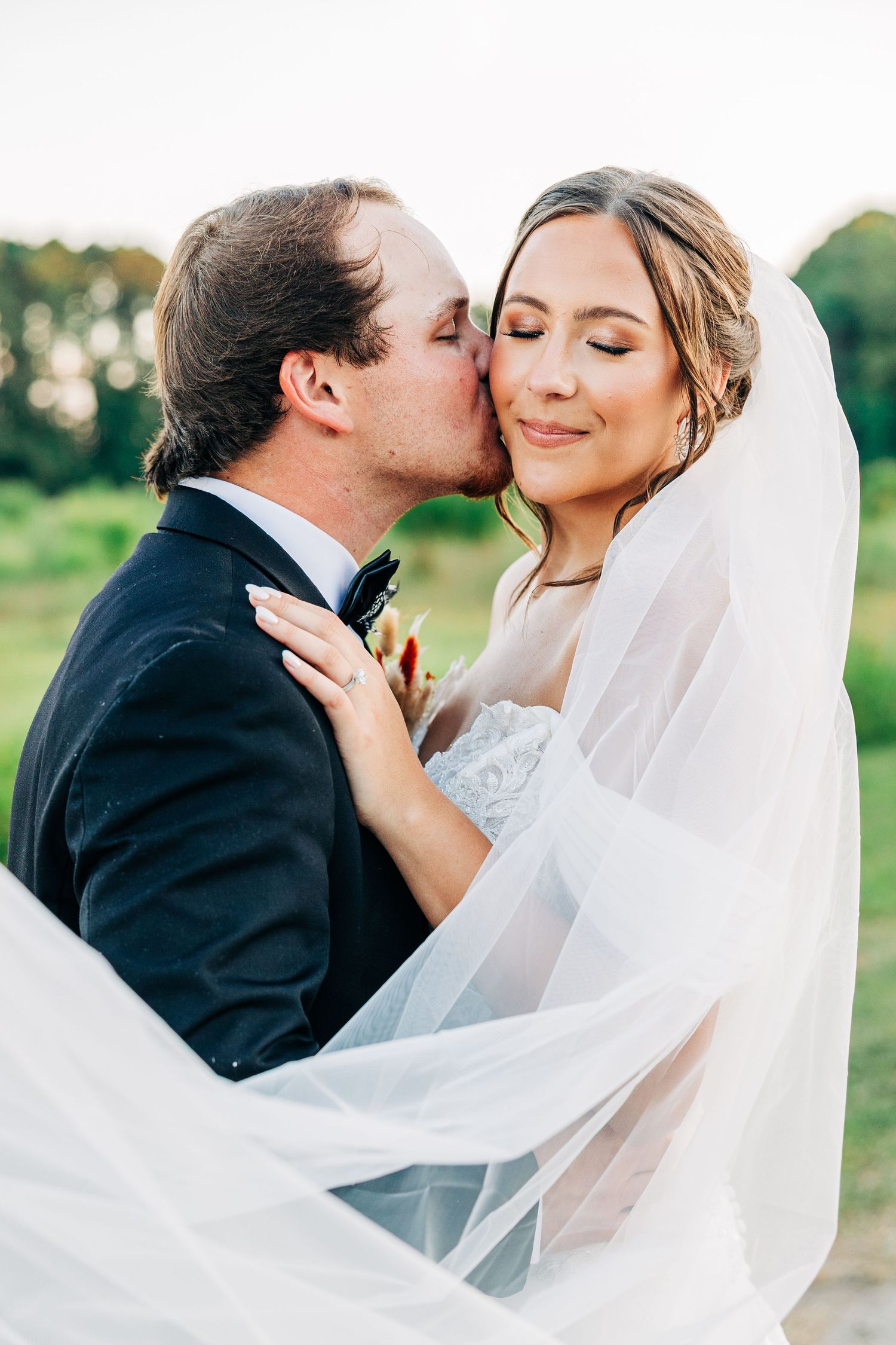 A romantic wedding photo sequence shows a couple sharing tender kisses under a flowing white veil in an outdoor setting.