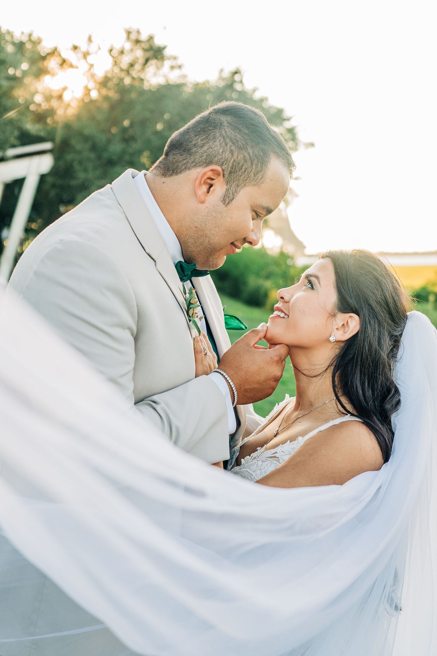 Romantic sunset portraits of couple with flowing white veil.