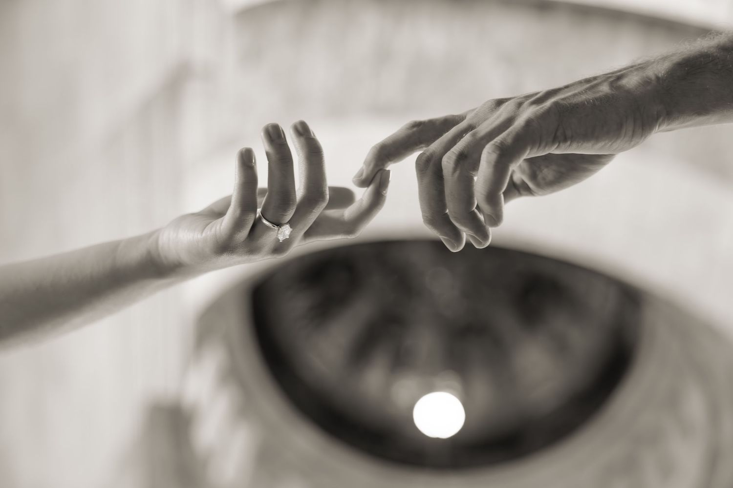Artistic black and white macro shot of wedding rings with dramatic lighting.