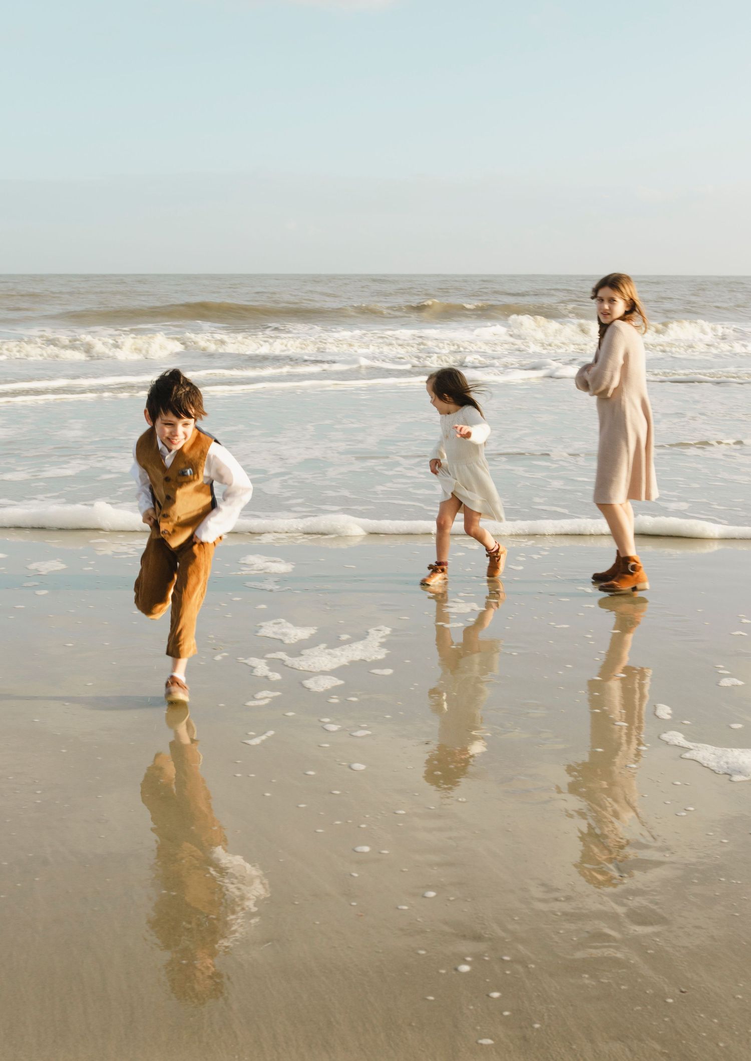 Kids running by the ocean. Sunset