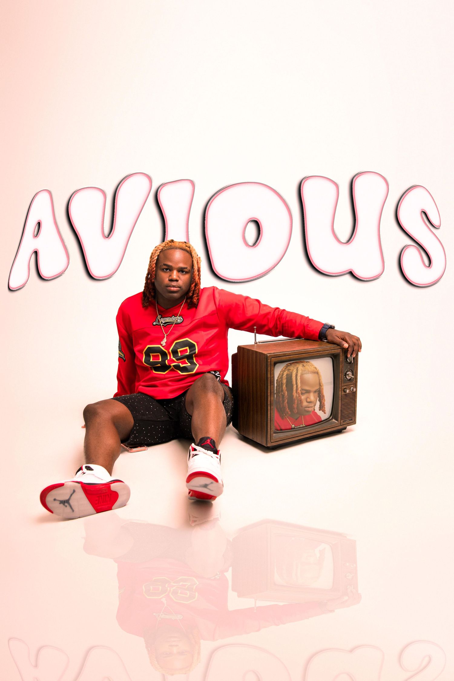 Young man in red jersey and Jordan sneakers sits beside a vintage TV displaying a woman, with bold AVIOUS text behind him.
