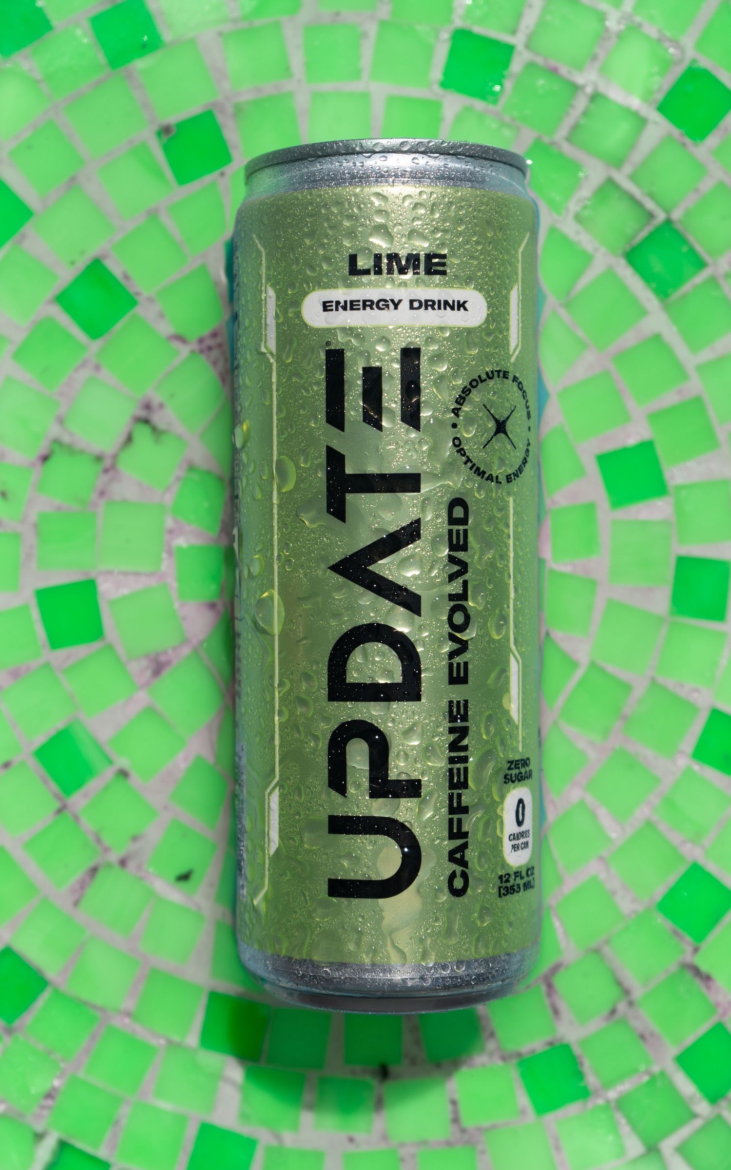 Lime flavored UPDATE energy drink can on green mosaic pattern background.