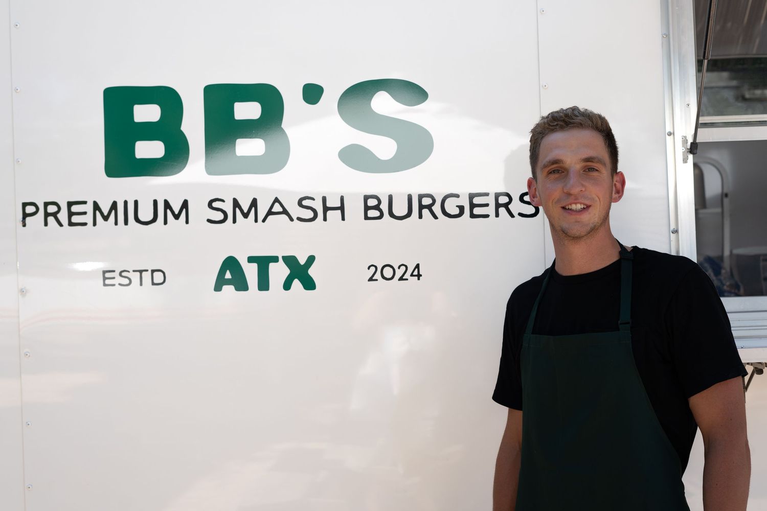 Interior photo of a modern burger restaurant with green lettering and signage showing 'BB's Premium Smash Burgers'.