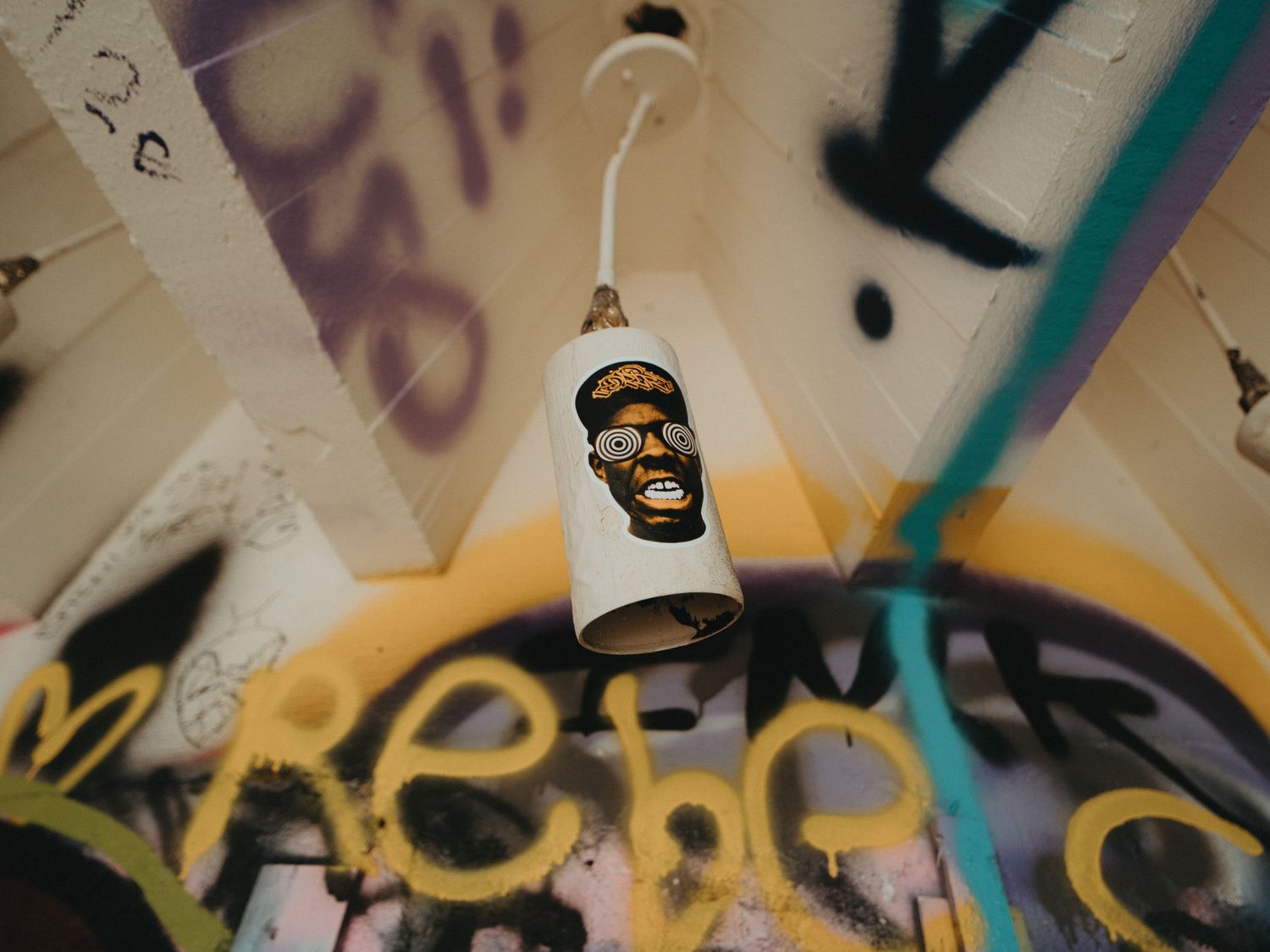 Colorful abstract graffiti art decorates a wall with swirling patterns and vibrant designs in an urban setting.