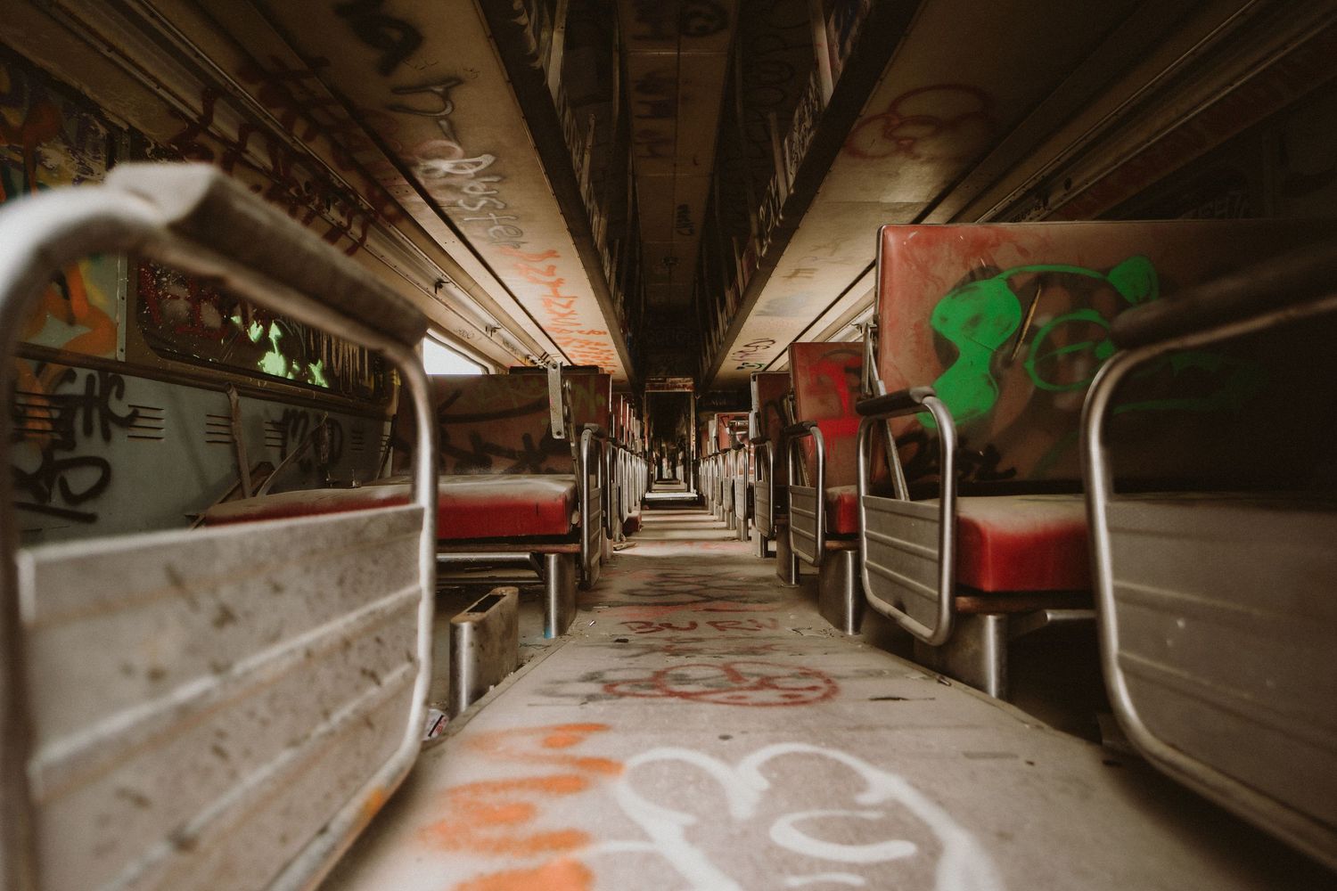 Long abandoned subway tunnel with graffiti-covered walls and tracks stretching into the darkness.