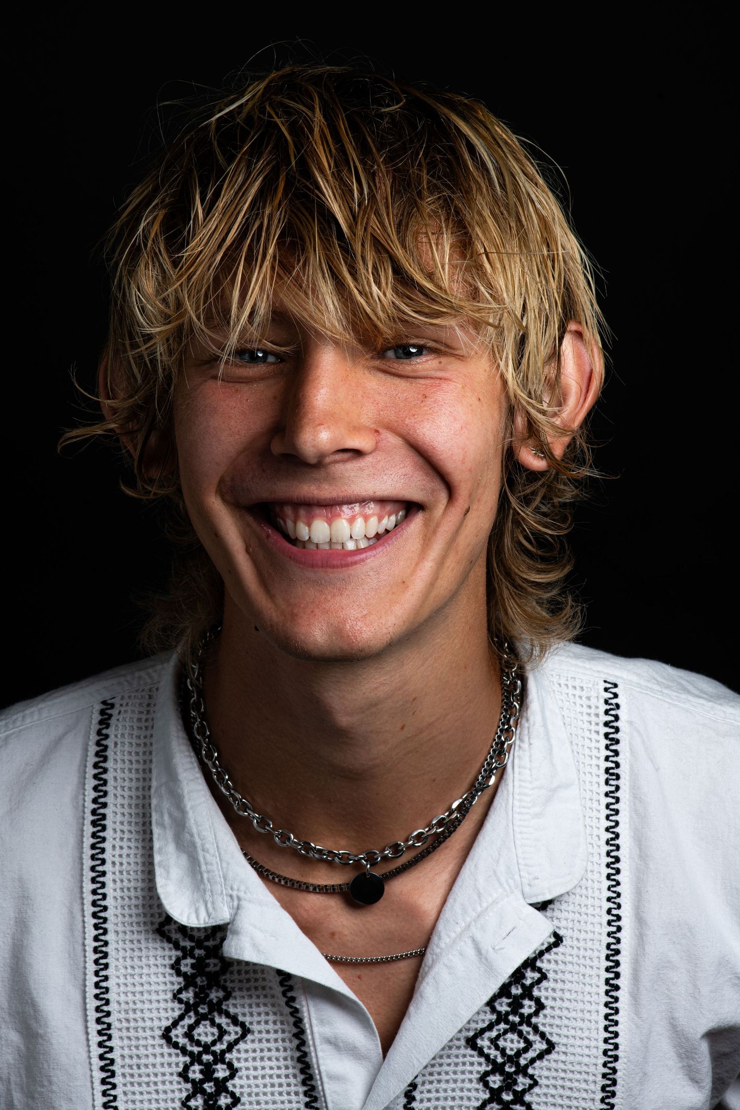 Portrait against a black background shows a brand and lifestyle photographer named Ethan Ege