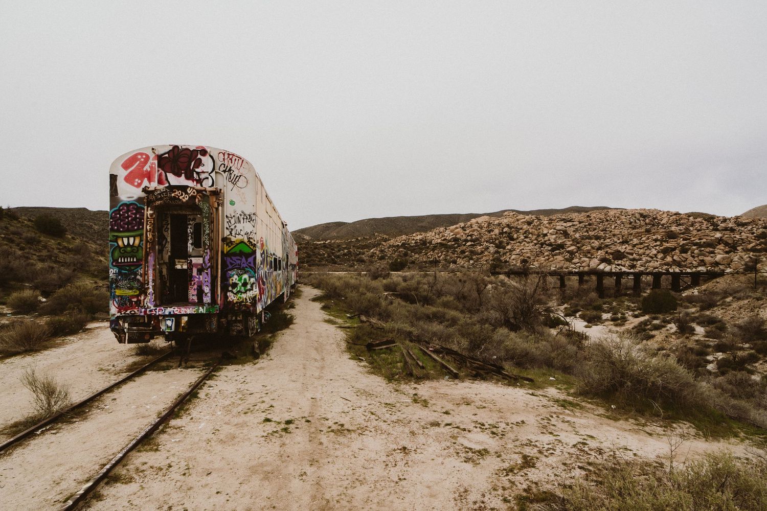 A series of scenic views along a desert hiking trail with rugged terrain and scattered vegetation in the background.