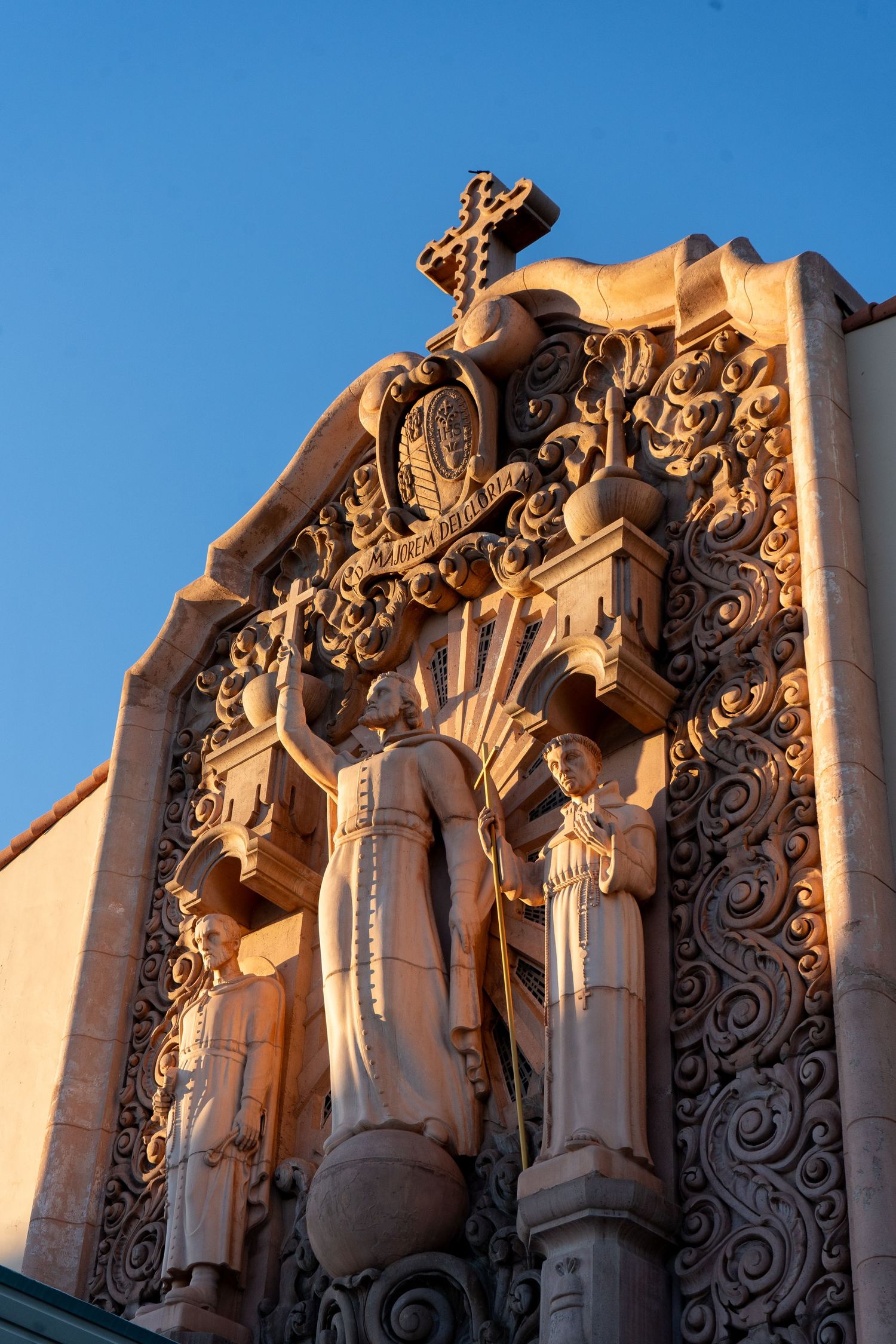 Ornate stone carved religious figures on church exterior against blue sky.
