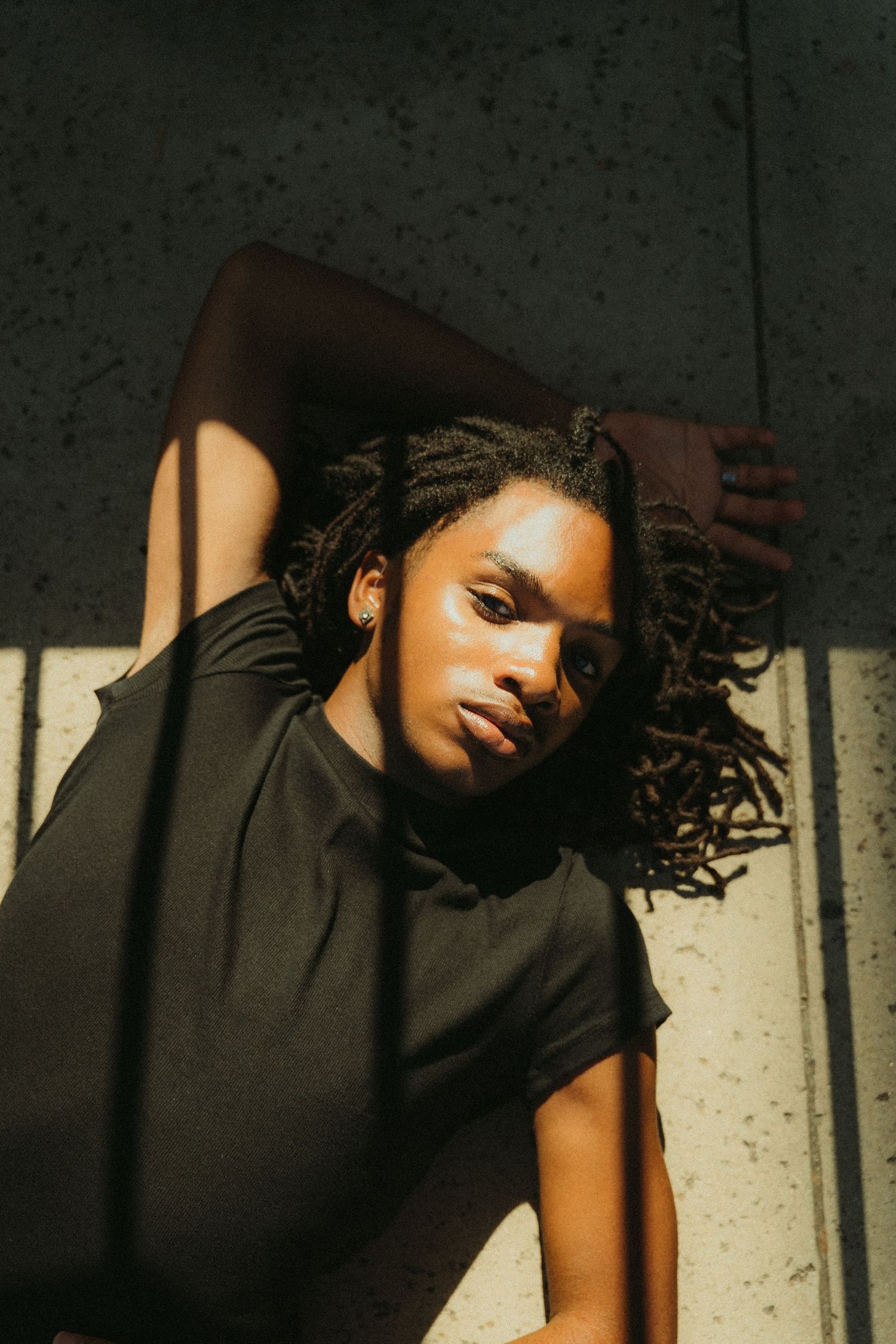 A series of artistic portraits showing dramatic lighting and shadows against a textured wall background.