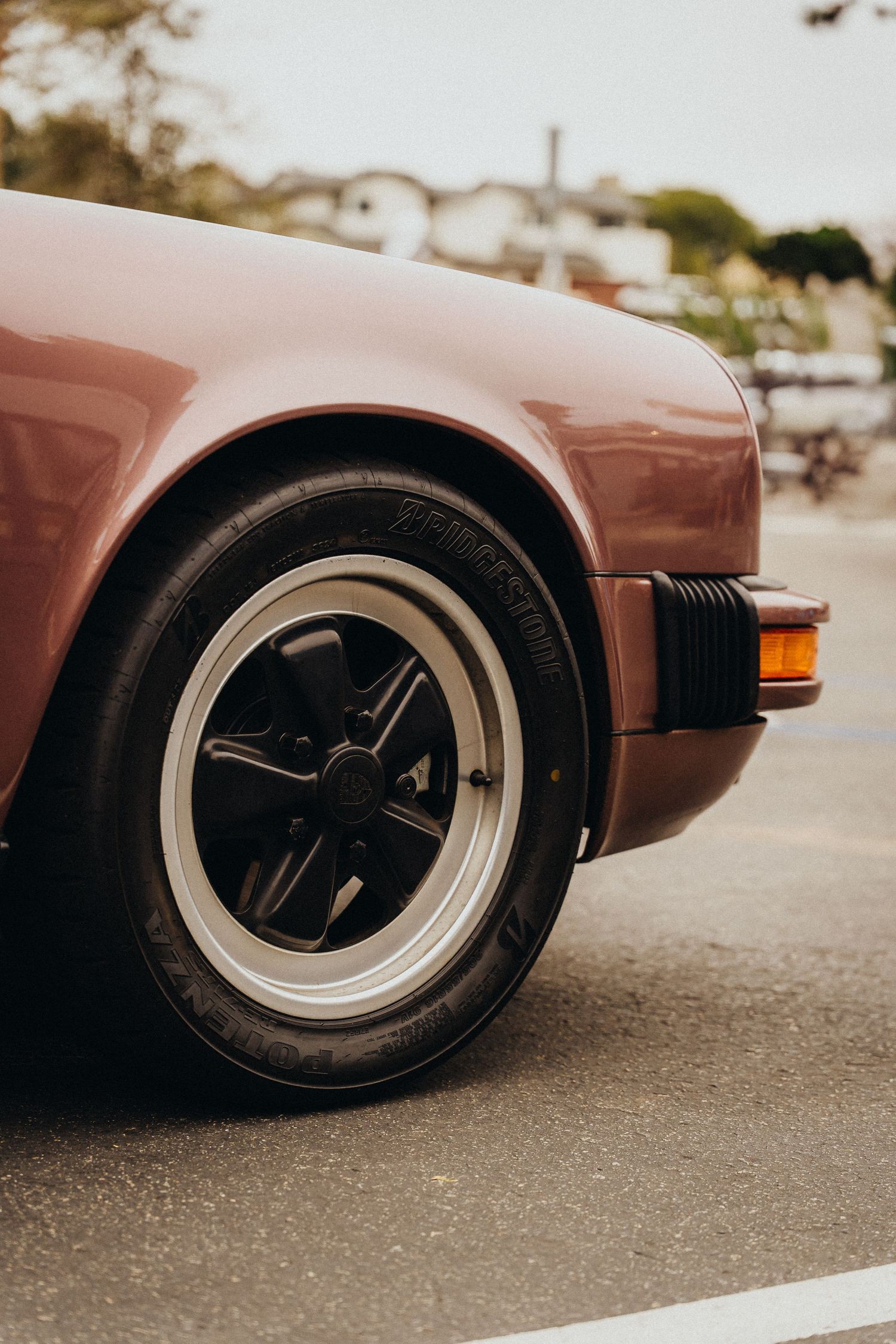 Close-up sequence of a classic Porsche 911 wheel and tire detail showing artistic angles and warm brown tones.