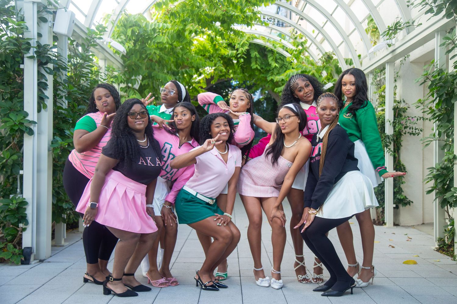 A group of people in colorful clothing lean to one side while posing together outdoors in a synchronized motion.