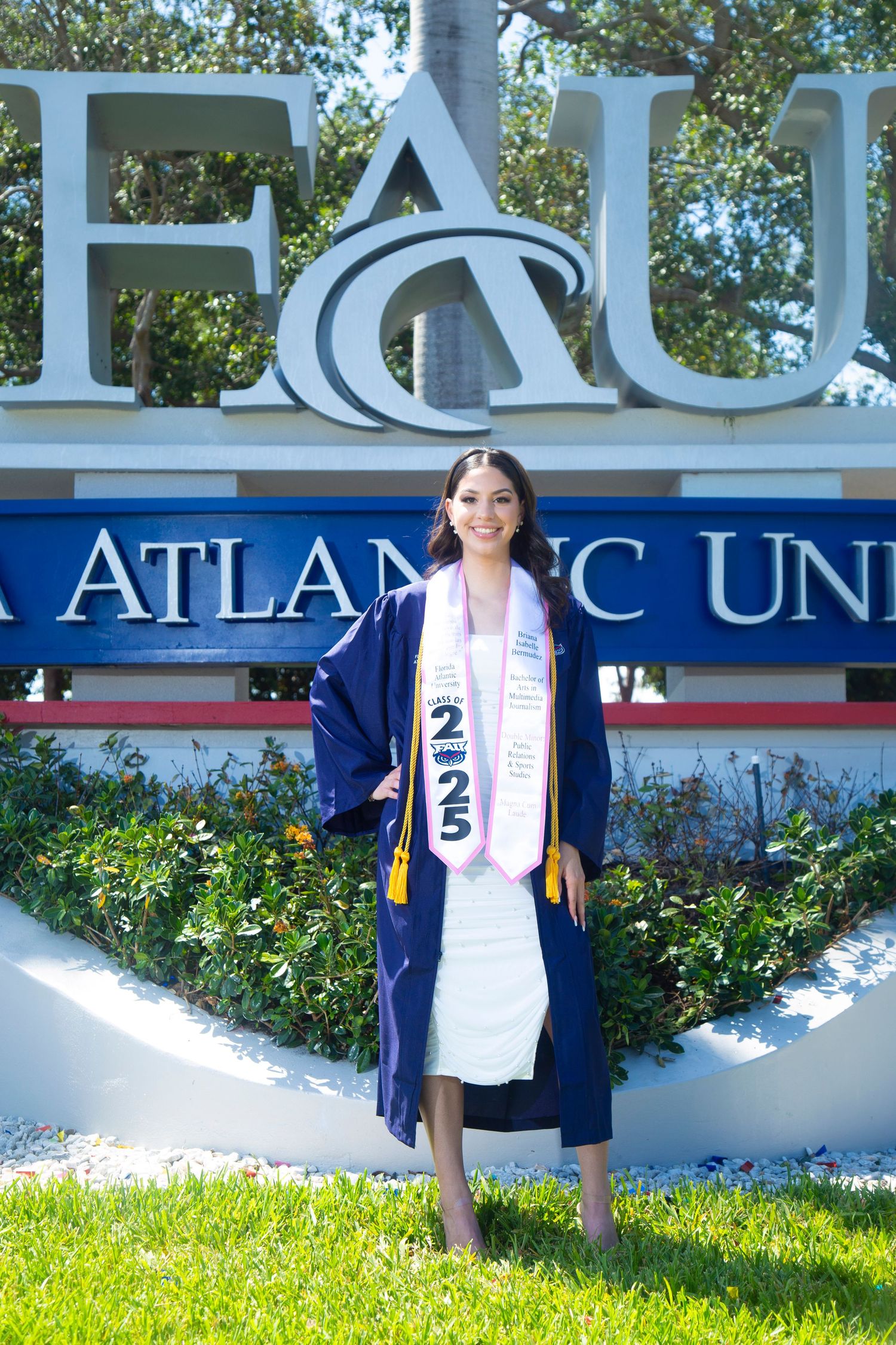 A graduation photo session at Florida Atlantic University's entrance sign.