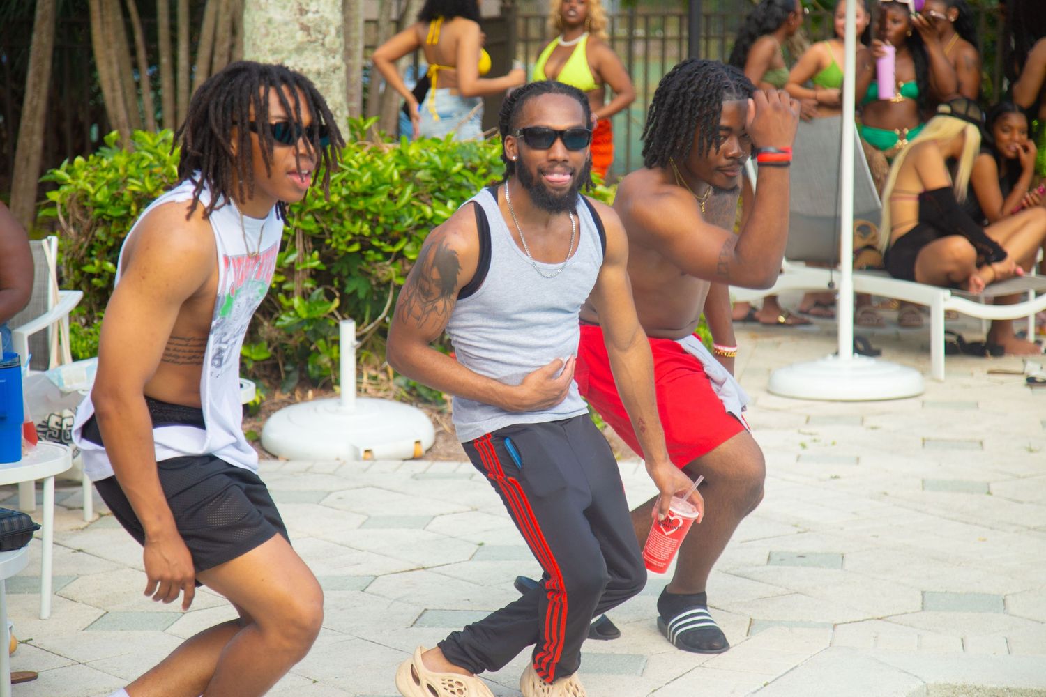 Three friends dancing and having fun on outdoor patio.