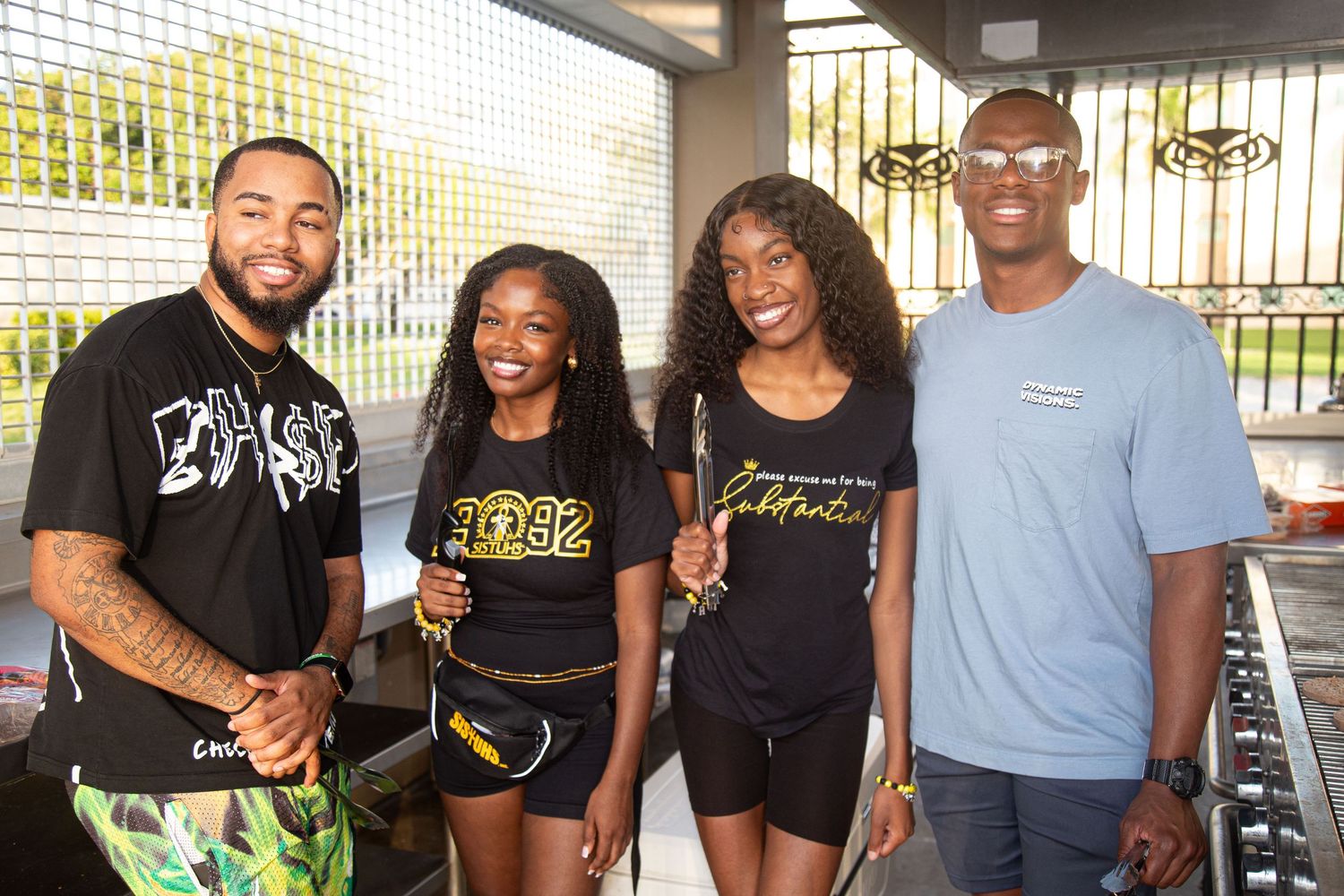 Small group wearing matching black t-shirts posing together at an event.