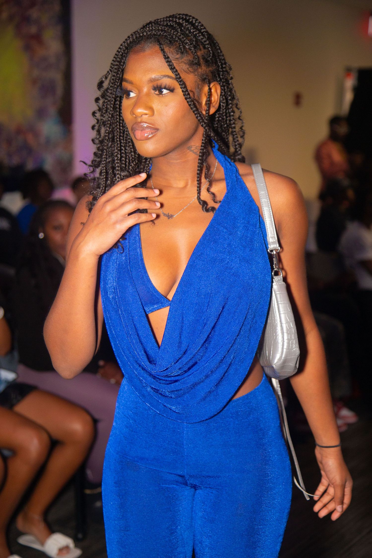 A fashion show model walking the runway in a flowing blue evening gown.