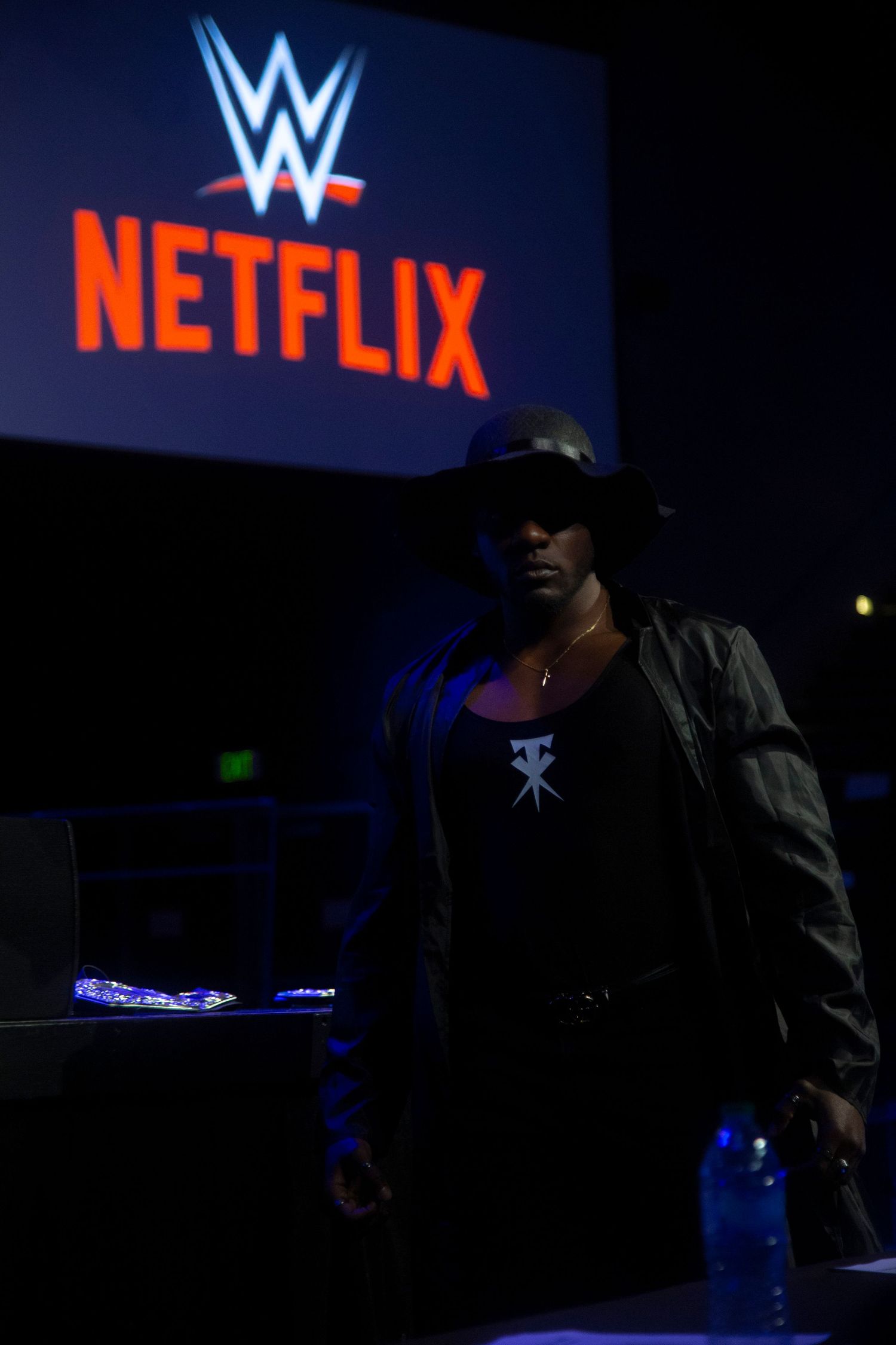Silhouetted figure stands beneath WWE and Netflix logos in dramatic lighting.