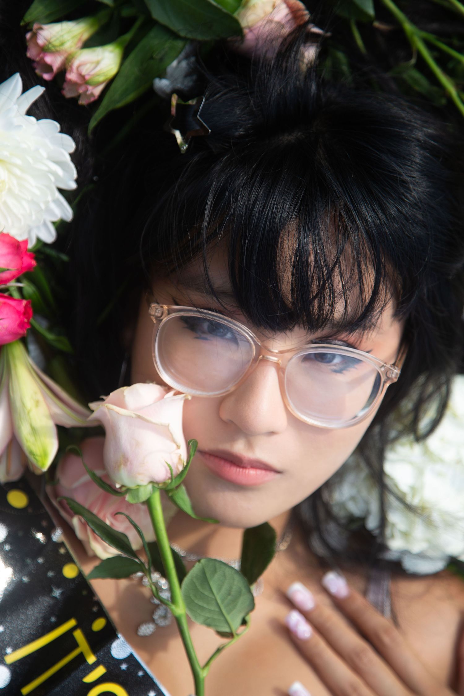Artistic portrait with roses and clear glasses in soft natural lighting.