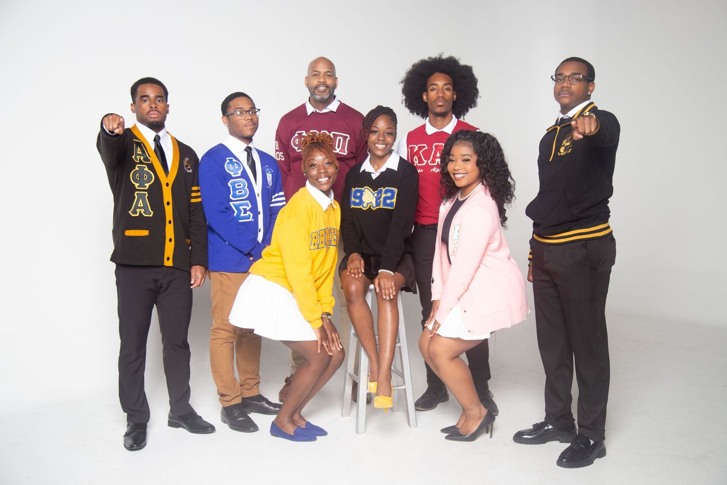 Stylized group portrait featuring collegiate apparel and coordinated poses.