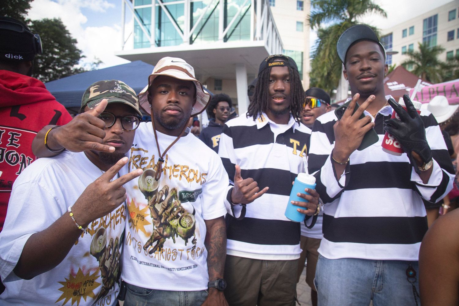 A group of people wearing white t-shirts and hats gather together at an outdoor event.