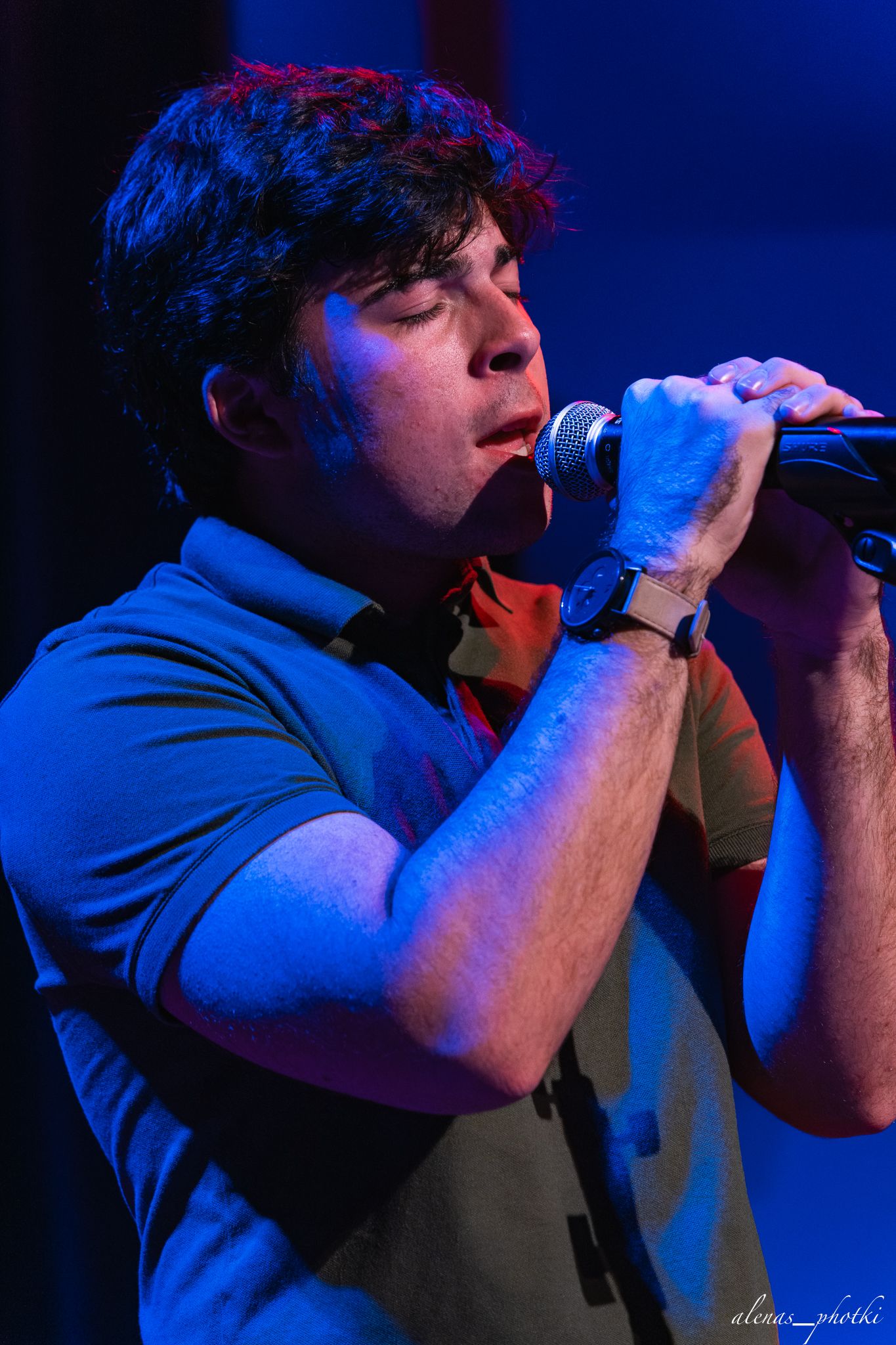 A singer performs on stage under dramatic blue lighting, shown in a sequence of close-up profile shots.